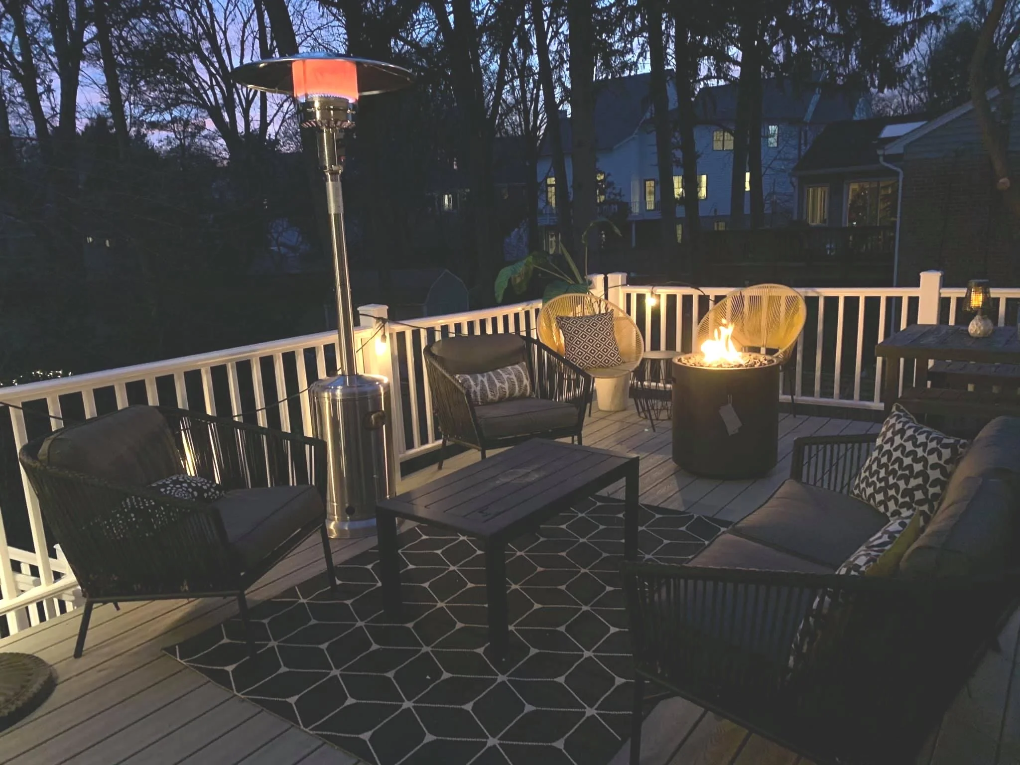 AFTER: I defined an outdoor "living room" conversation area with a rug and coffee table surrounded by these great black chairs and loveseat from Target years ago, all warmed by a patio heater. In the corner, two yellow chairs nestle up to the firepit