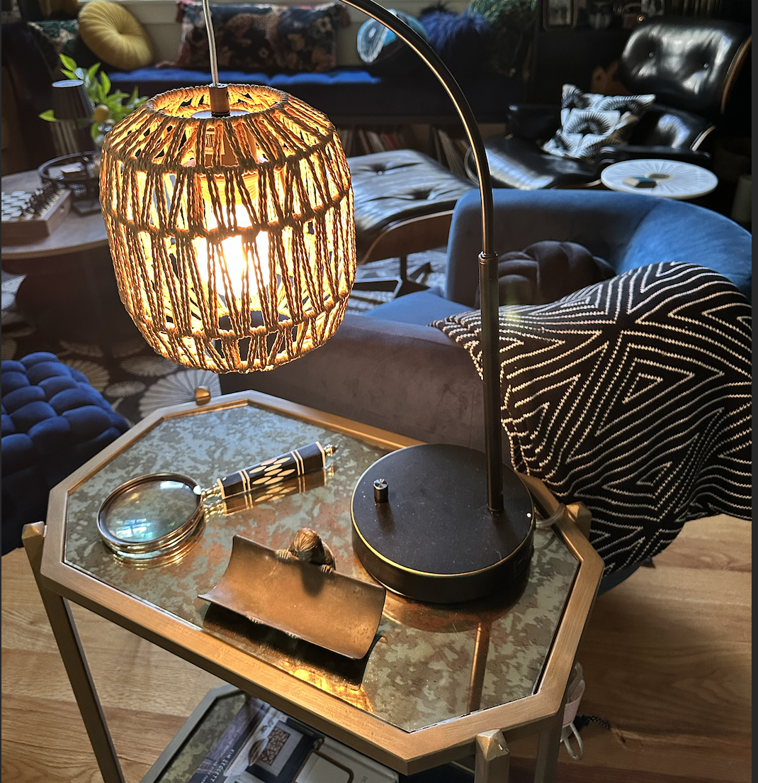 AFTER: an antiqued mirror top on this elongated octagonal side table reflects the light from the woven lampshade. 