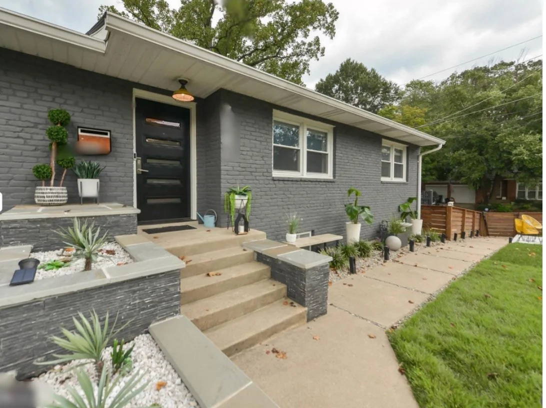 AFTER: New everything. Gray paint on the brick, new mailbox, new door, new house numbers, and an ingenious (if I do say so myself) plan to redo the front porch without jackhammering out any of the old stuff (including the ramp). A planter covers the 