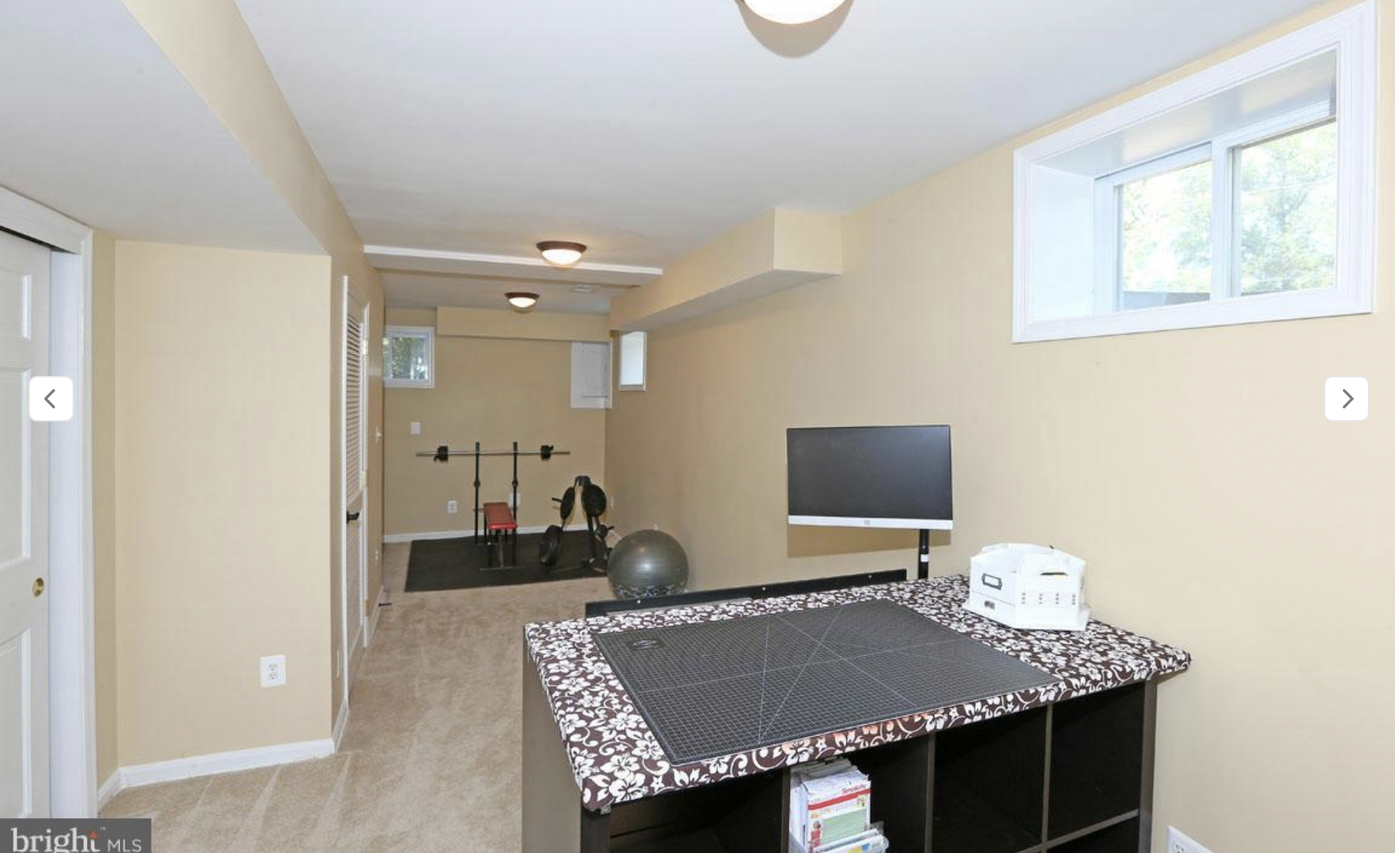 BEFORE: A narrow bowling alley of a basement room, being used as a workout space and a crafting area. An all-around depressing space. 