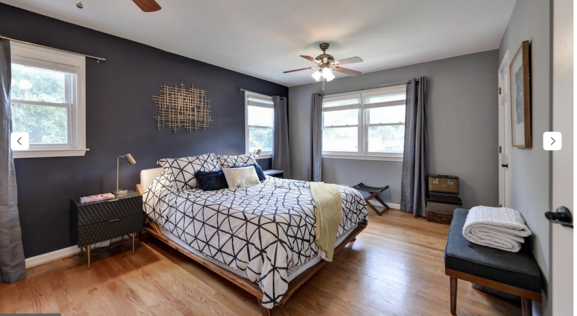 AFTER: gray walls continue in from the hallway for continuity, with one dark blue accent wall. Coordinating bedding, a nice bench to take shoes on and off, and low-key curtains and this looks like a whole different room. This was a very small budget 