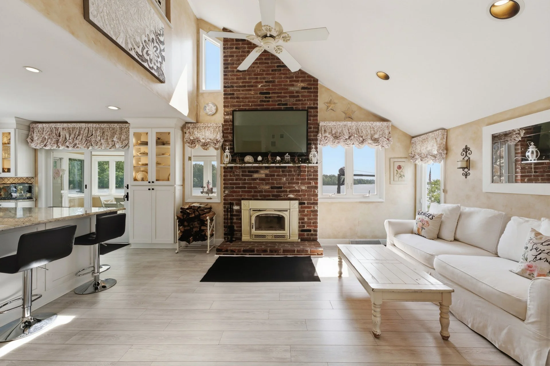 Soaring vaulted ceilings and a dramatic floor-to-ceiling brick fireplace anchor the living space