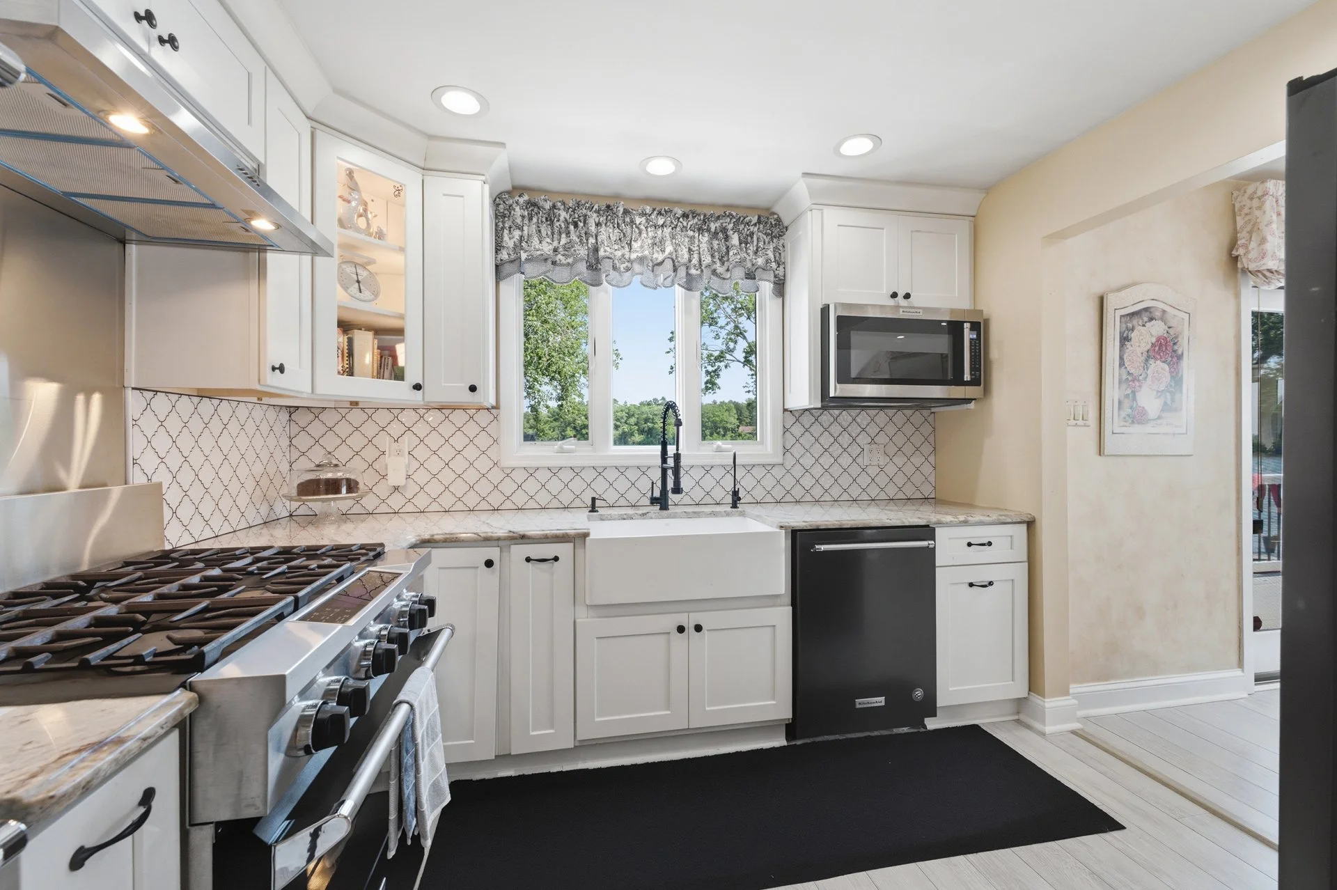 The updated kitchen features granite countertops, an oversized center island, and commercial-grade appliances.