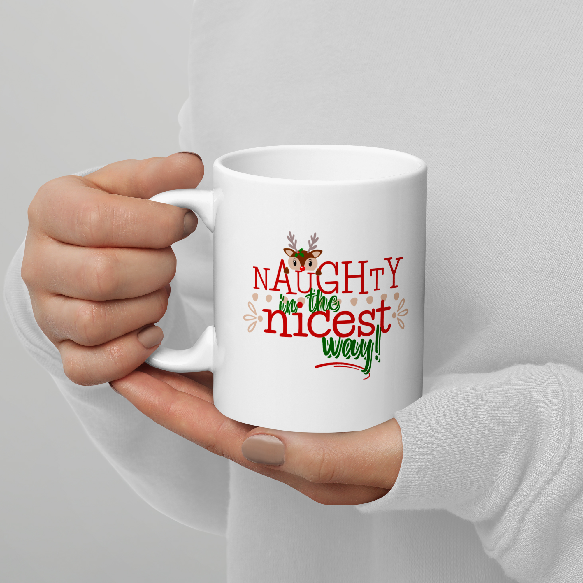 Hand modeling a 20 oz white glossy coffee mug with the cute reindeer design that says Naughty in the Nicest Way.