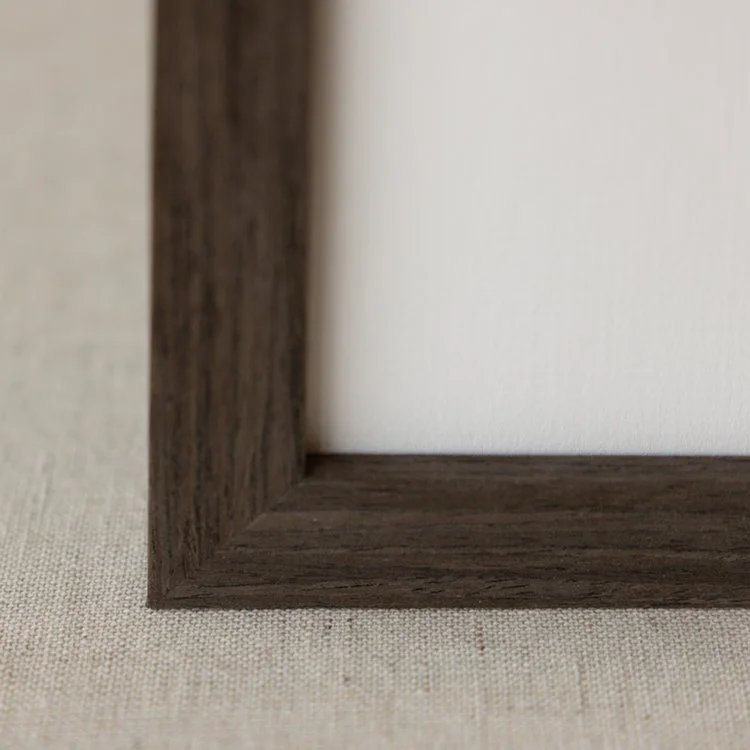 Close-up of a dark wooden picture frame corner on beige fabric background