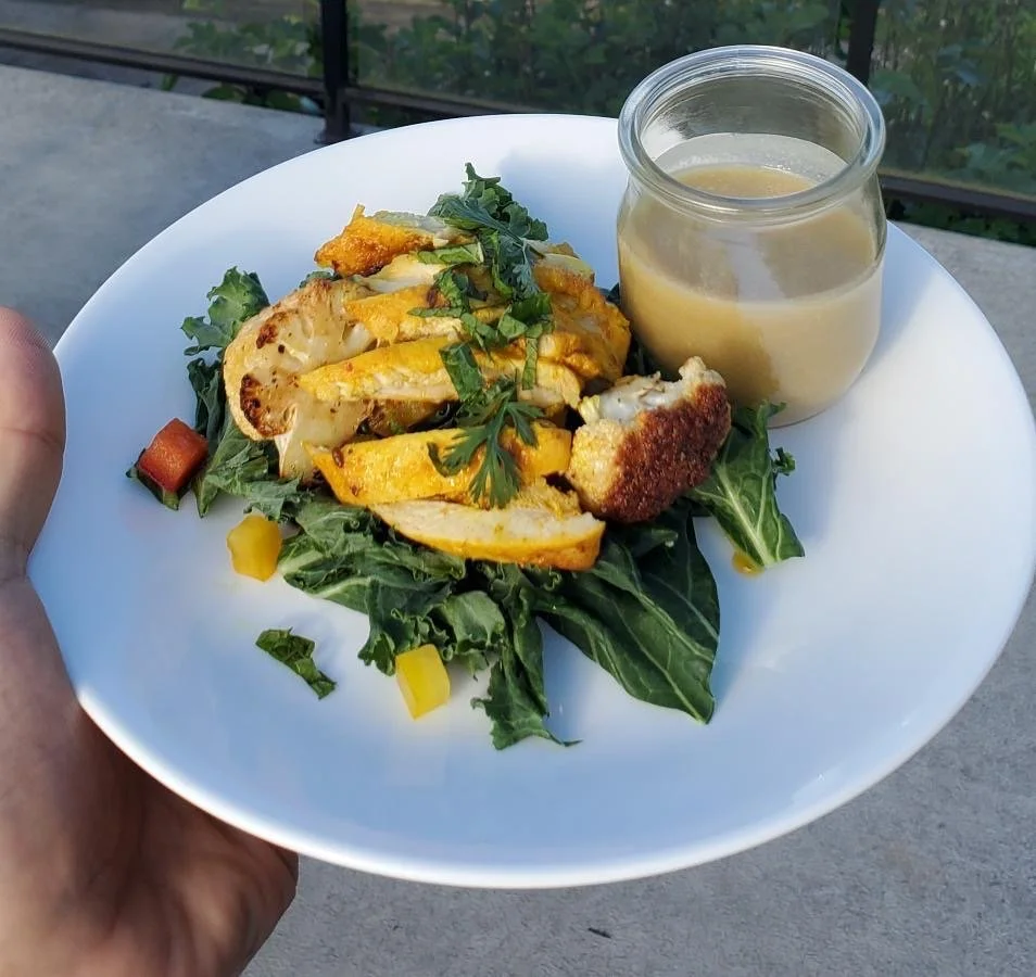 Curried chicken and bell pepper salad with a bed of spinach and kale alongside with a tahini yogurt dressing.