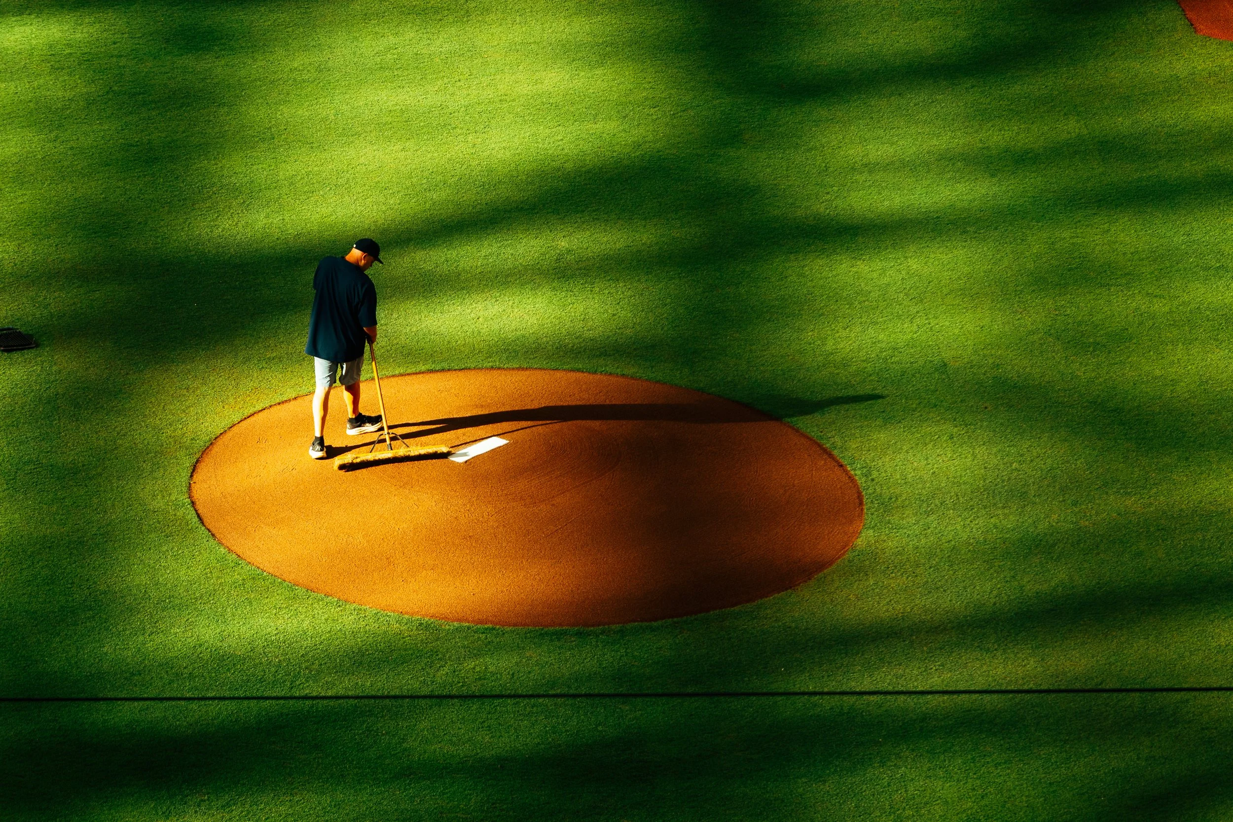 A grounds crew member prepping the mound at Daikin Park.