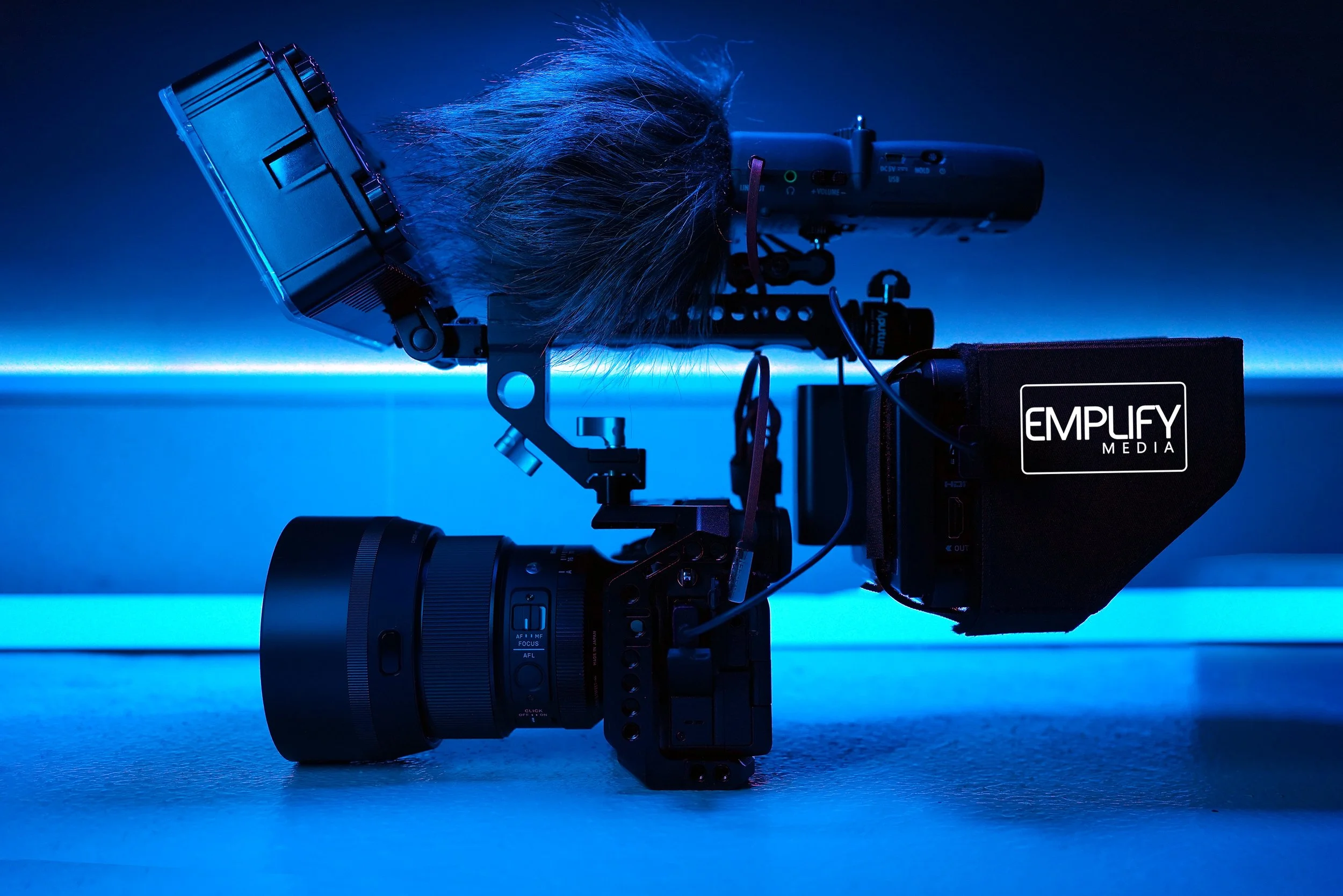 Close-up of professional camera mounted on a stabilizer rig with blue lighting.