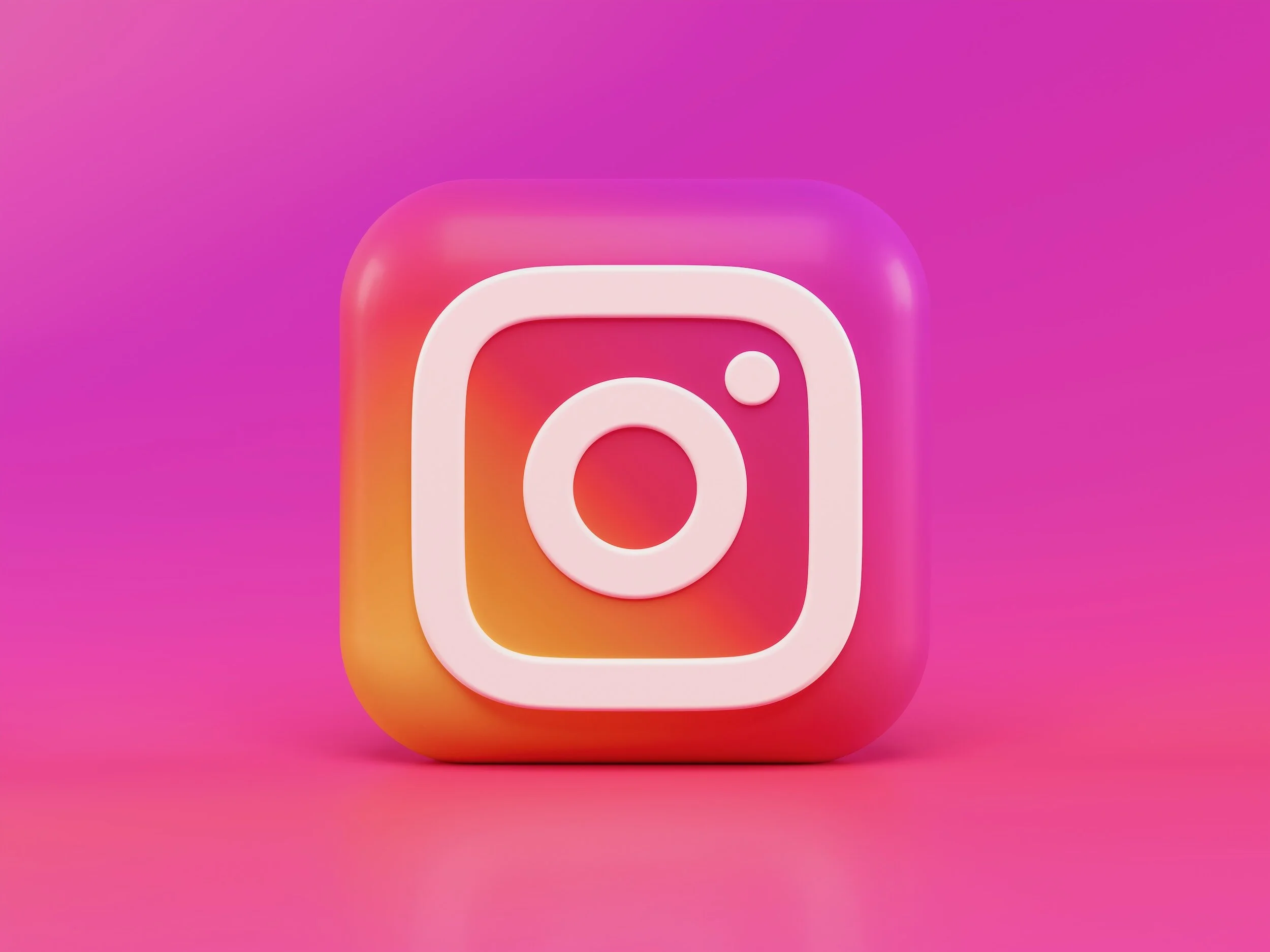 3D Instagram logo with a white outline on a pink and purple gradient background