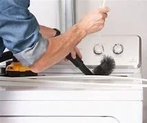 Person cleaning top of washing machine with a duster