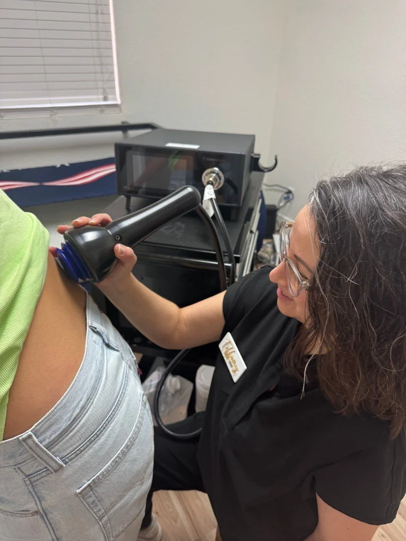 Tiffany giving an OMNIWave treatment on a patient's back