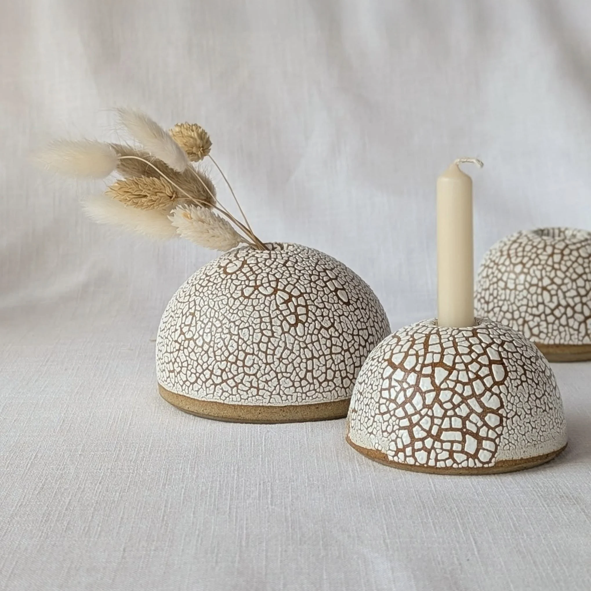 Assortment of handcrafted ceramic cups and saucers in various patterns and colors on display.