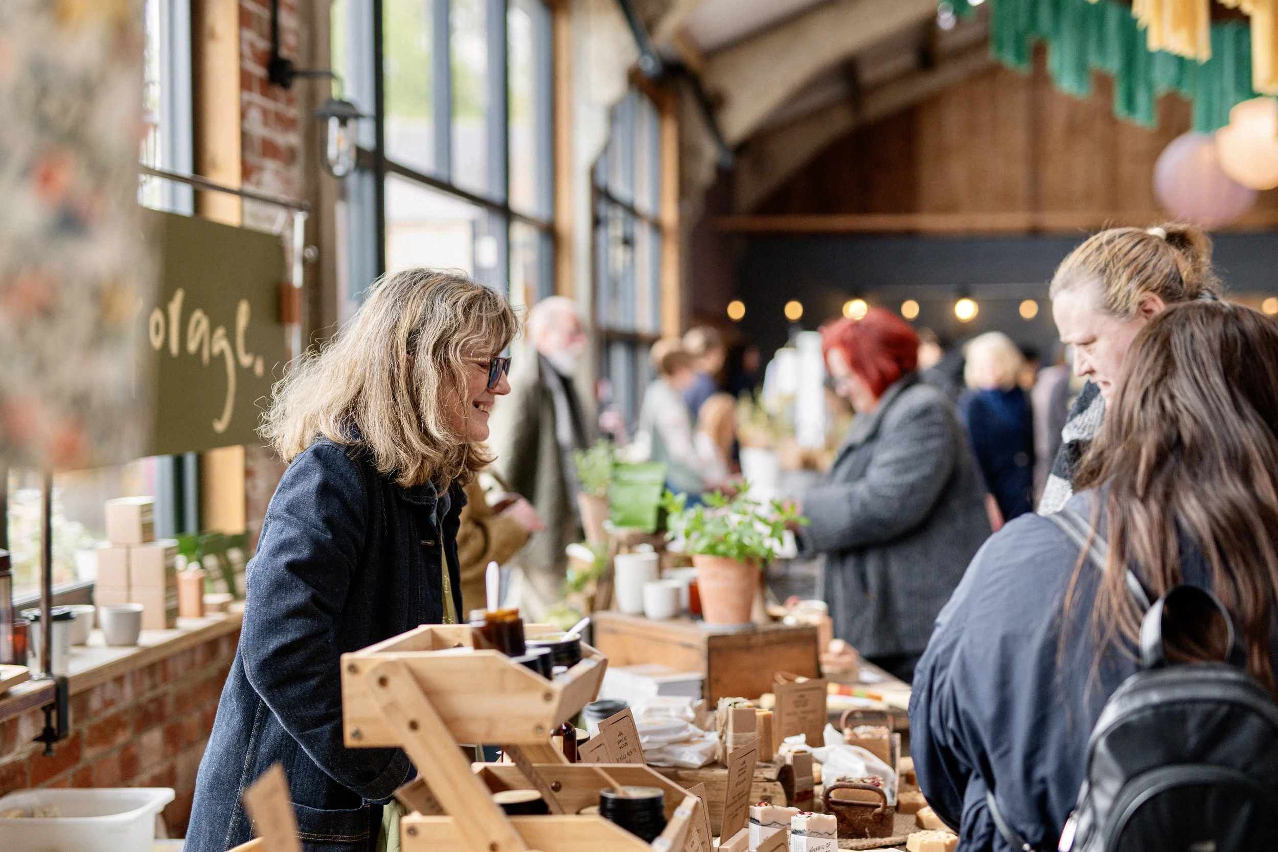 Crowded indoor market scene with people and hanging decorations.