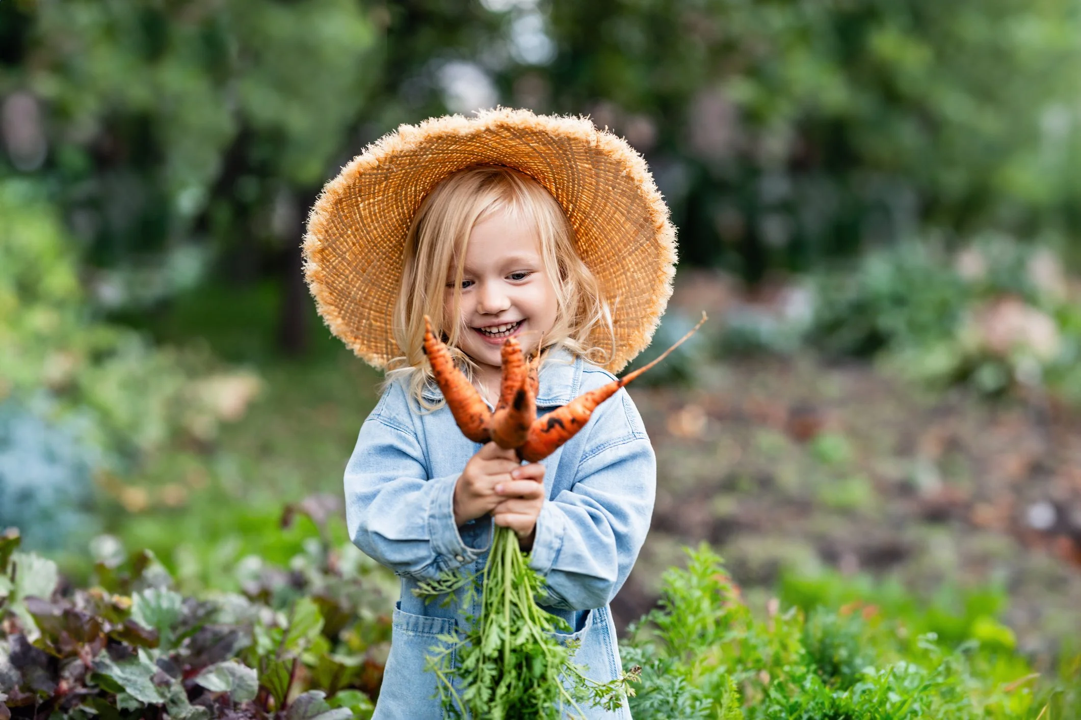 Girl holding carrots.