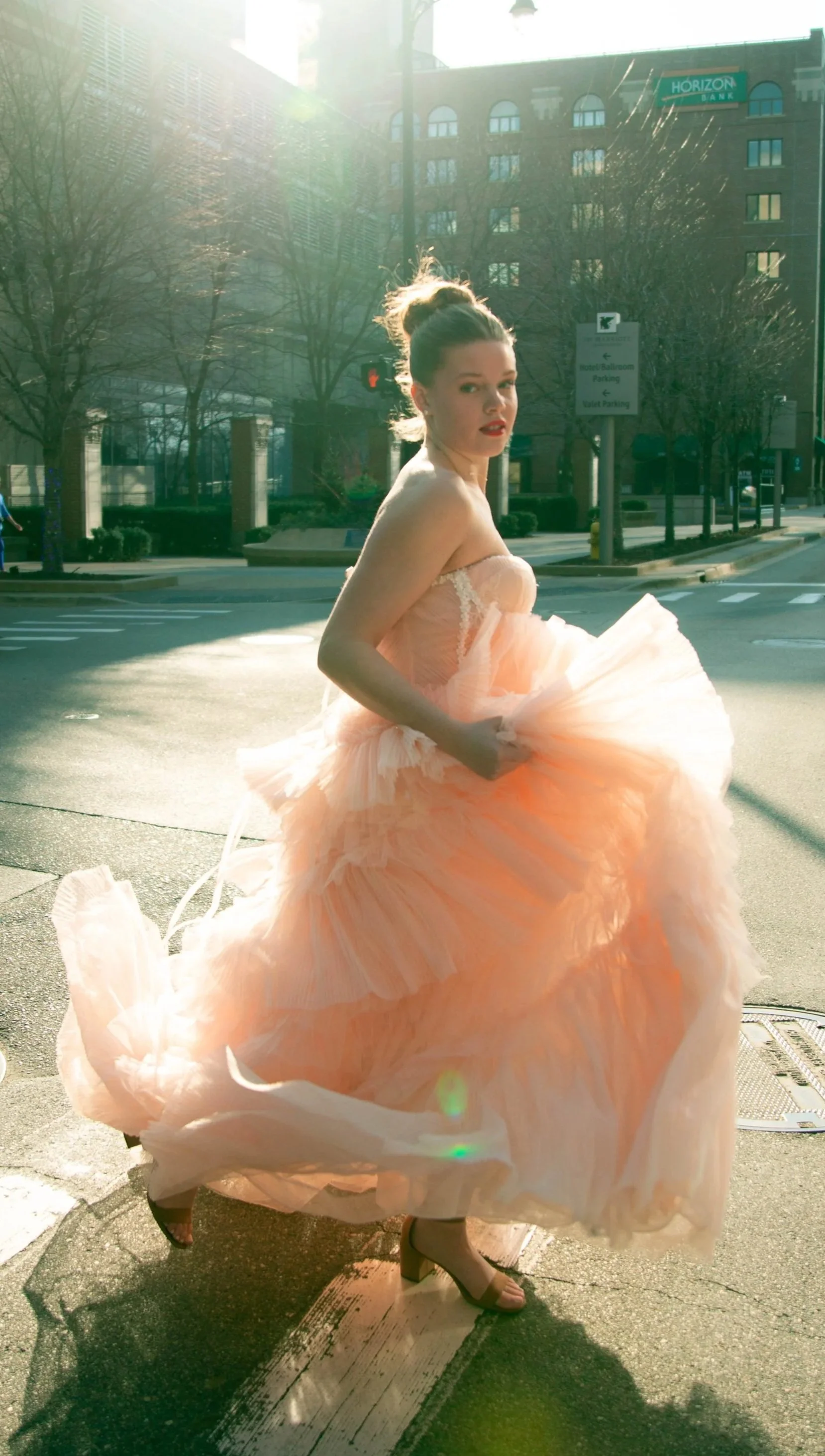 Editorial portrait of a model in a flowing pink dress running through downtown Grand Rapids — Grand Rapids photographer Olivia