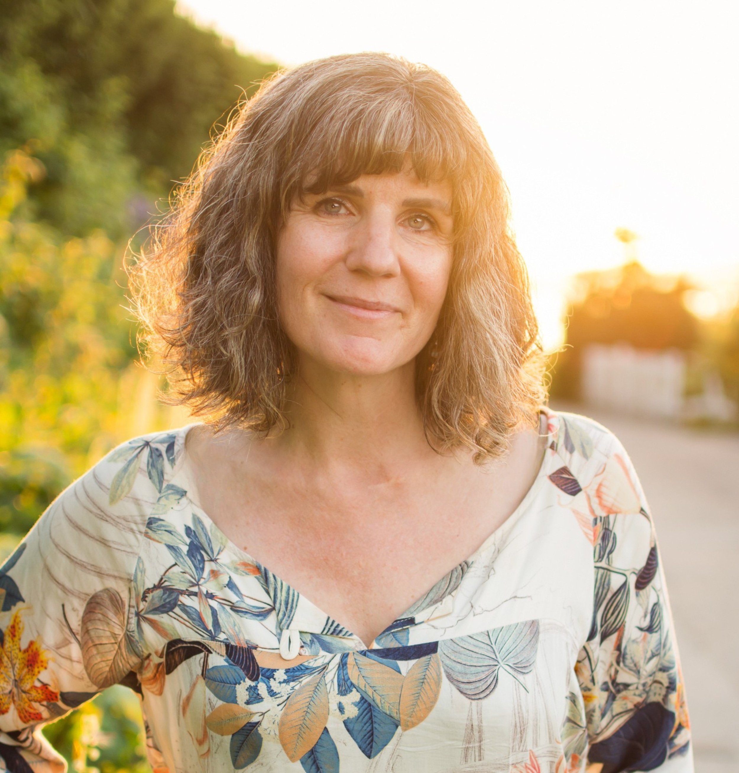 Roberta at golden hour, smiling warming in a floral dress