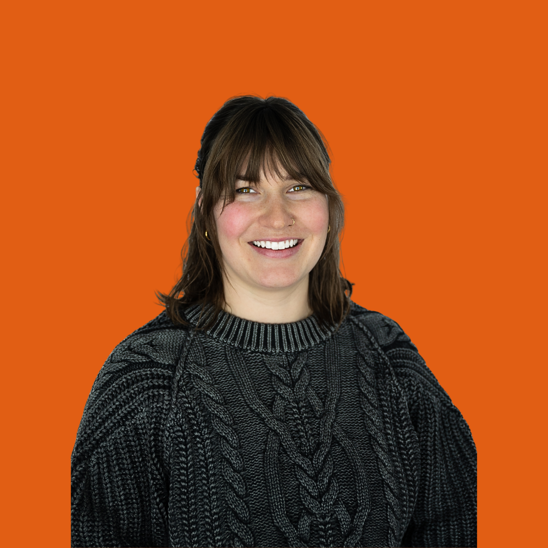 Kaeleigh Timm with shoulder-length brown hair wearing a dark gray sweater, smiling