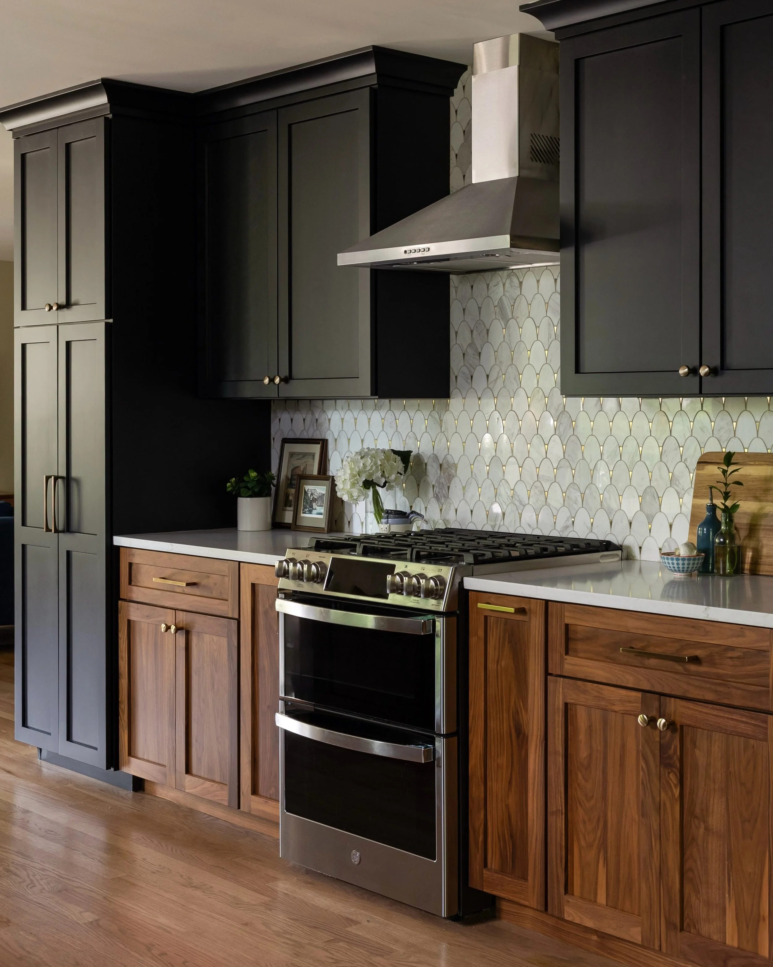 Fade to black; and walnut. The combination of wood finishes, along with the uniquely beautiful backsplash tile, makes this kitchen a one-of-a-kind space. 

Project: Black and Tan
Photos by @juliannegreeninteriorsphoto 

#blackandwalnutkitchen #blacka