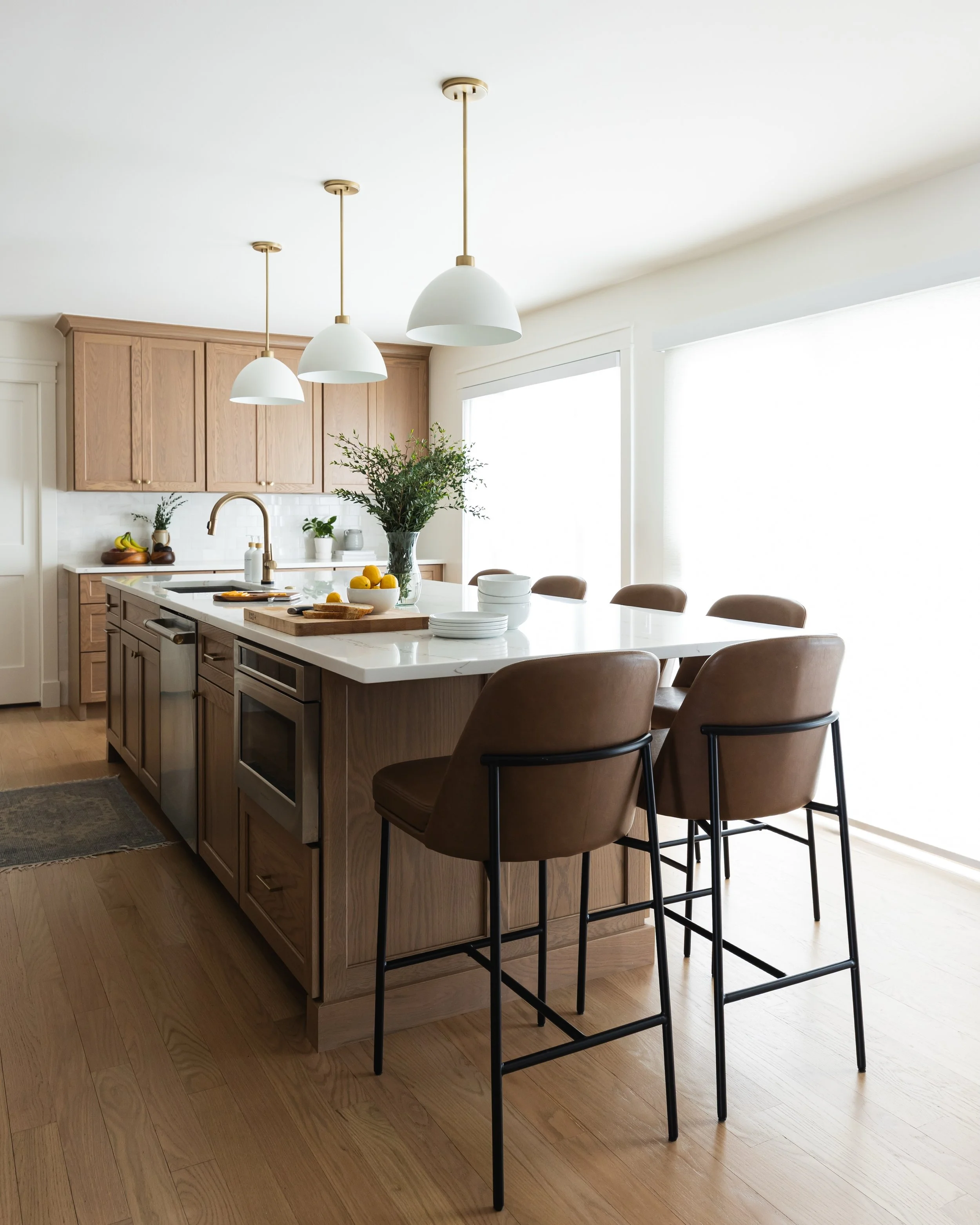 In order to create an island that comfortably seats six, we completely reimagined the kitchen layout by literally moving every main component and removing a whole run of cabinets. 

After expanding the island, adding tons of natural light, taking the