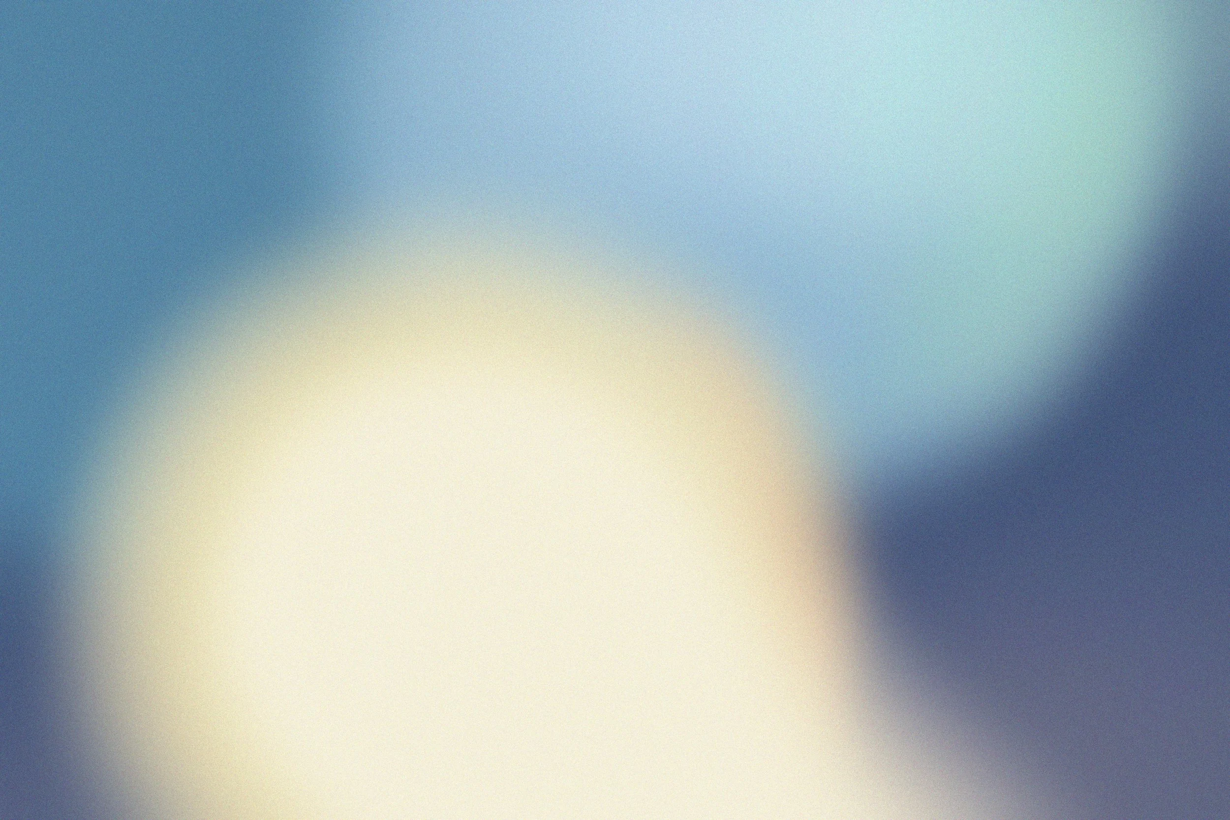 Blurred abstract background with shades of blue, white, and light green.