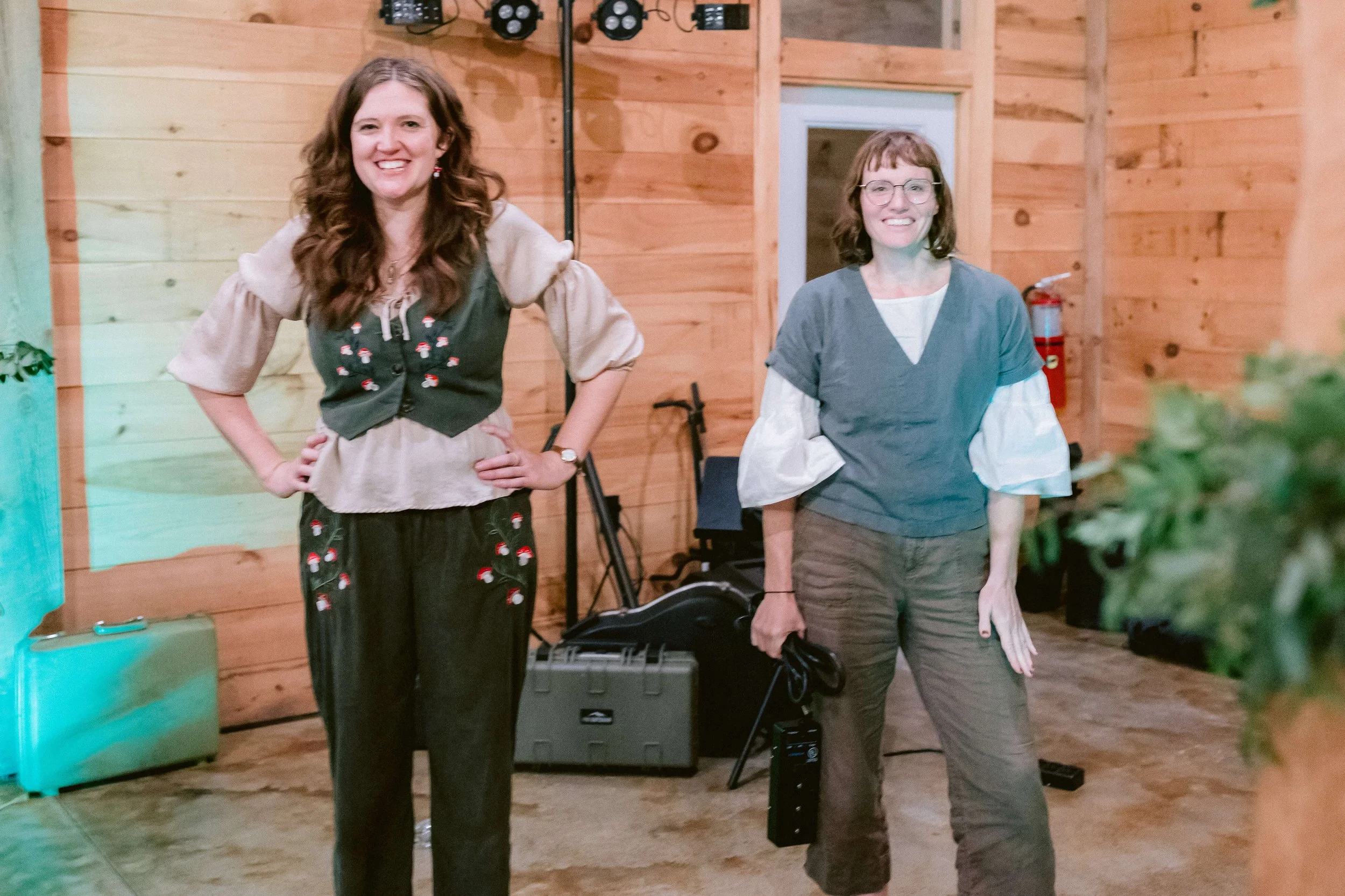 Holler & Crow: Lark Frazier and Ellison Graham are dressed as hobbits at a wedding performance. There is audio and lighting equipment on the floor