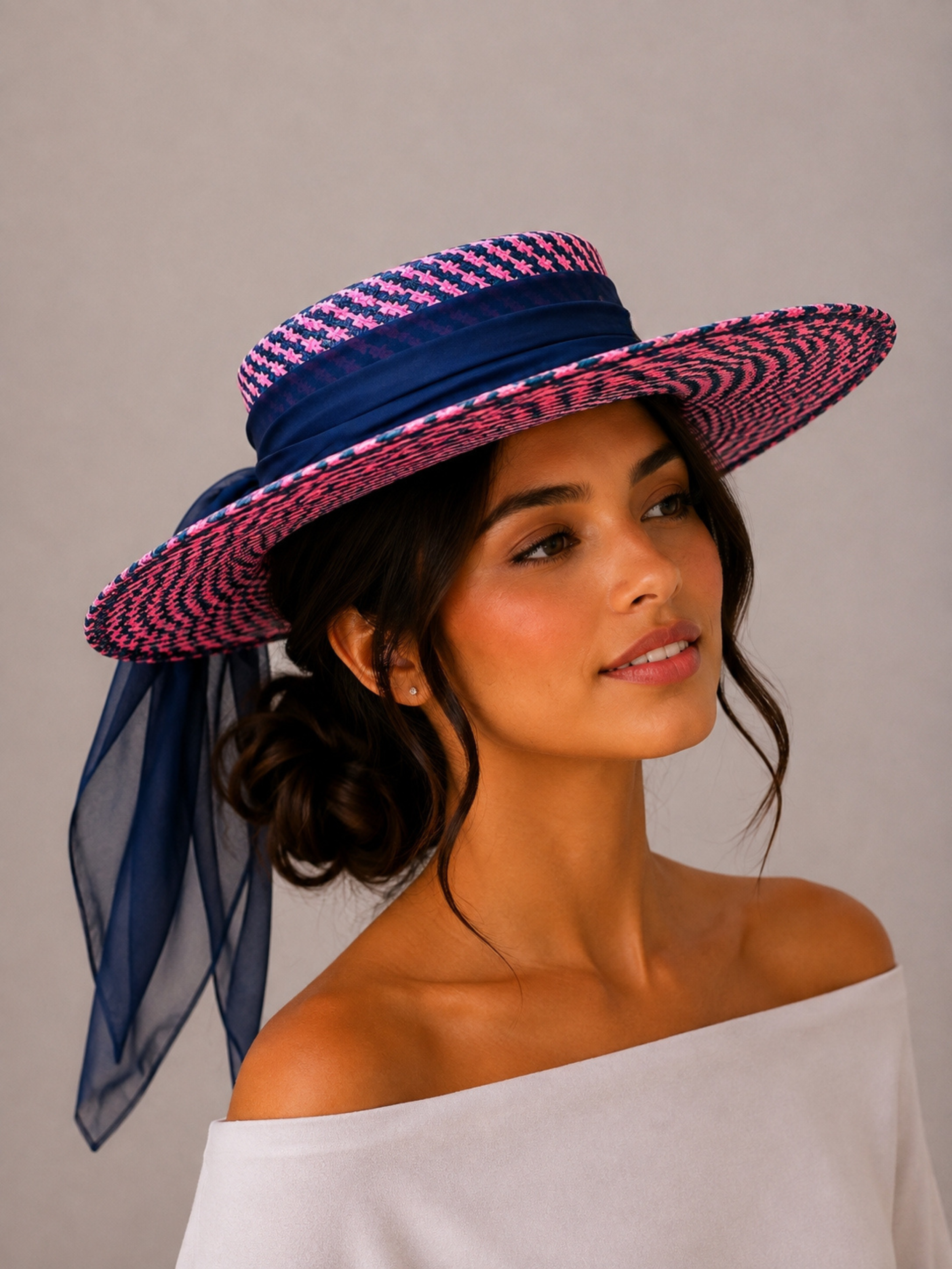 Solara Cerise woven boater hat styled on a model with a flowing dark blue silk chiffon tie.