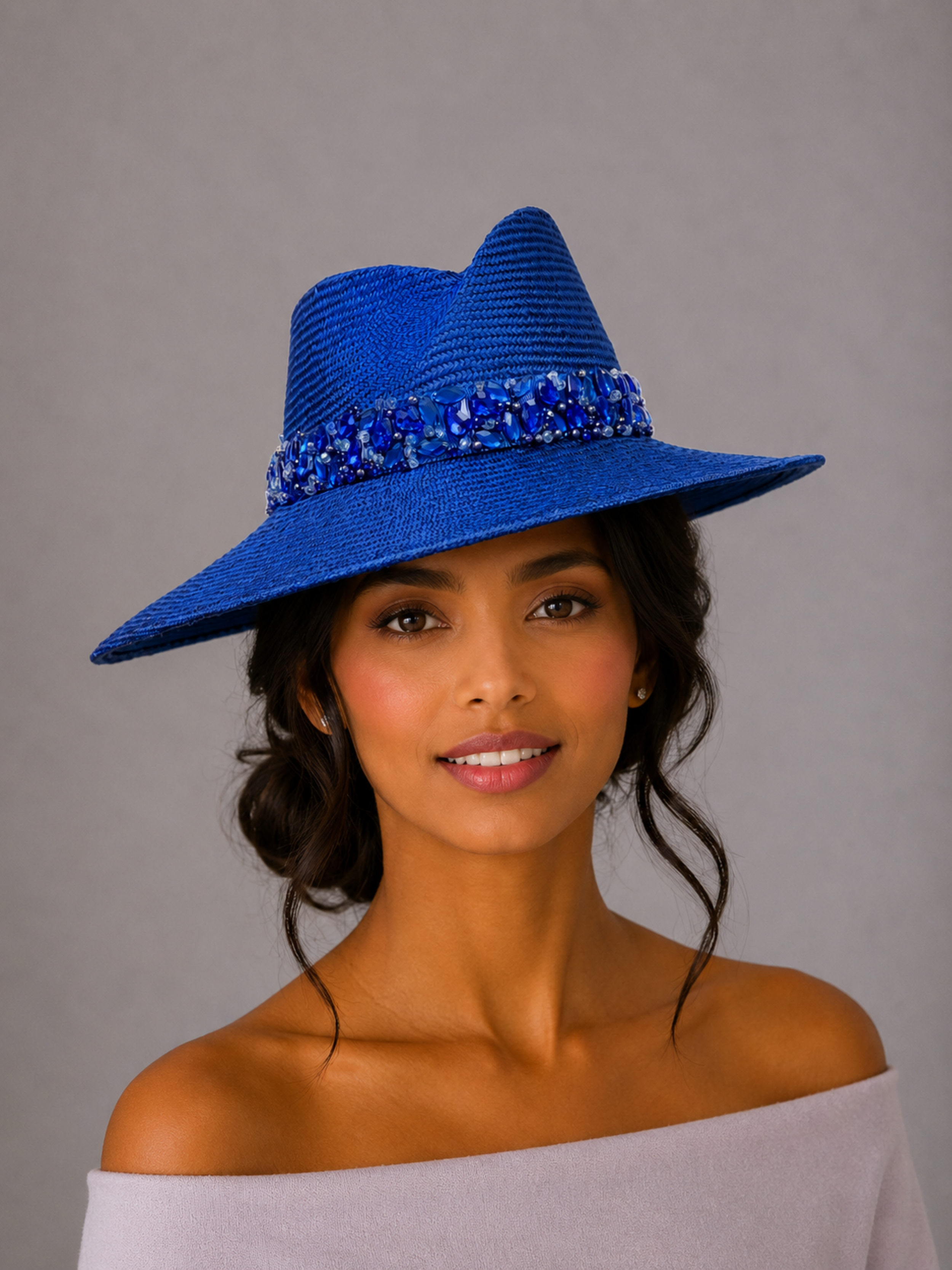 Model: MAISON Sapphire Parisisal fedora styled on a model, showcasing the statement silhouette and hand-embellished blue band.