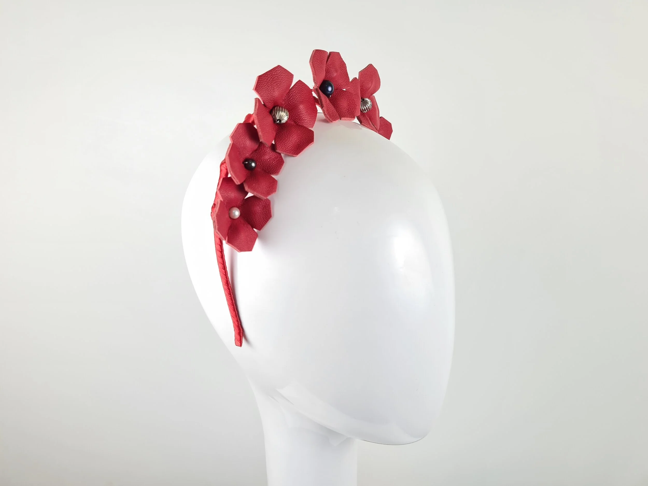 Another side view of the Red & Gold Leather Floral Crown Headband - Fiorella, displaying the elegant design and the attention to detail in the gold beaded centres.