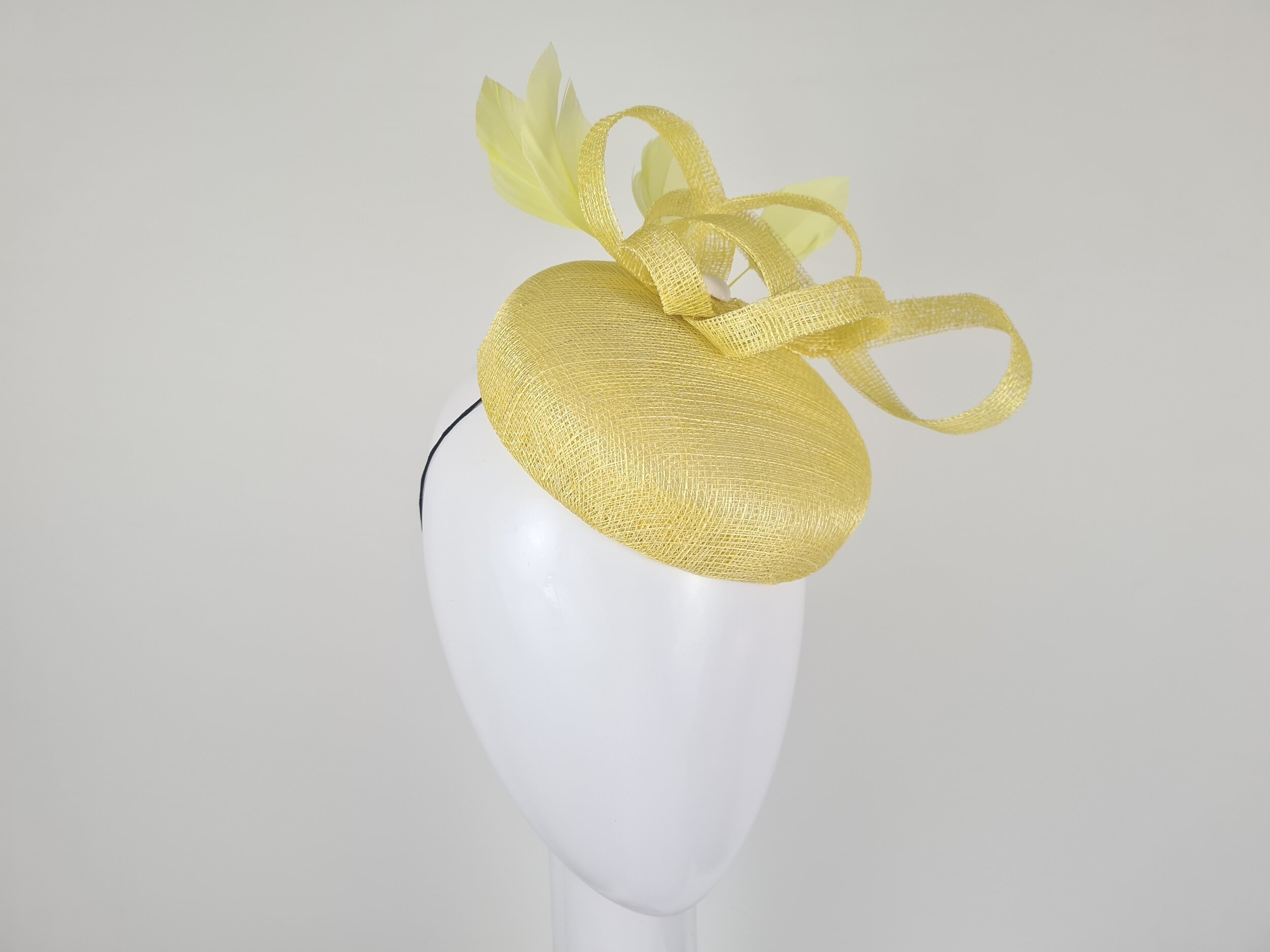 From the left, the 'Abril' reveals its delicate Sinamay and feather adornments. Hat elastic ensures a secure fit that's both stylish and comfortable.