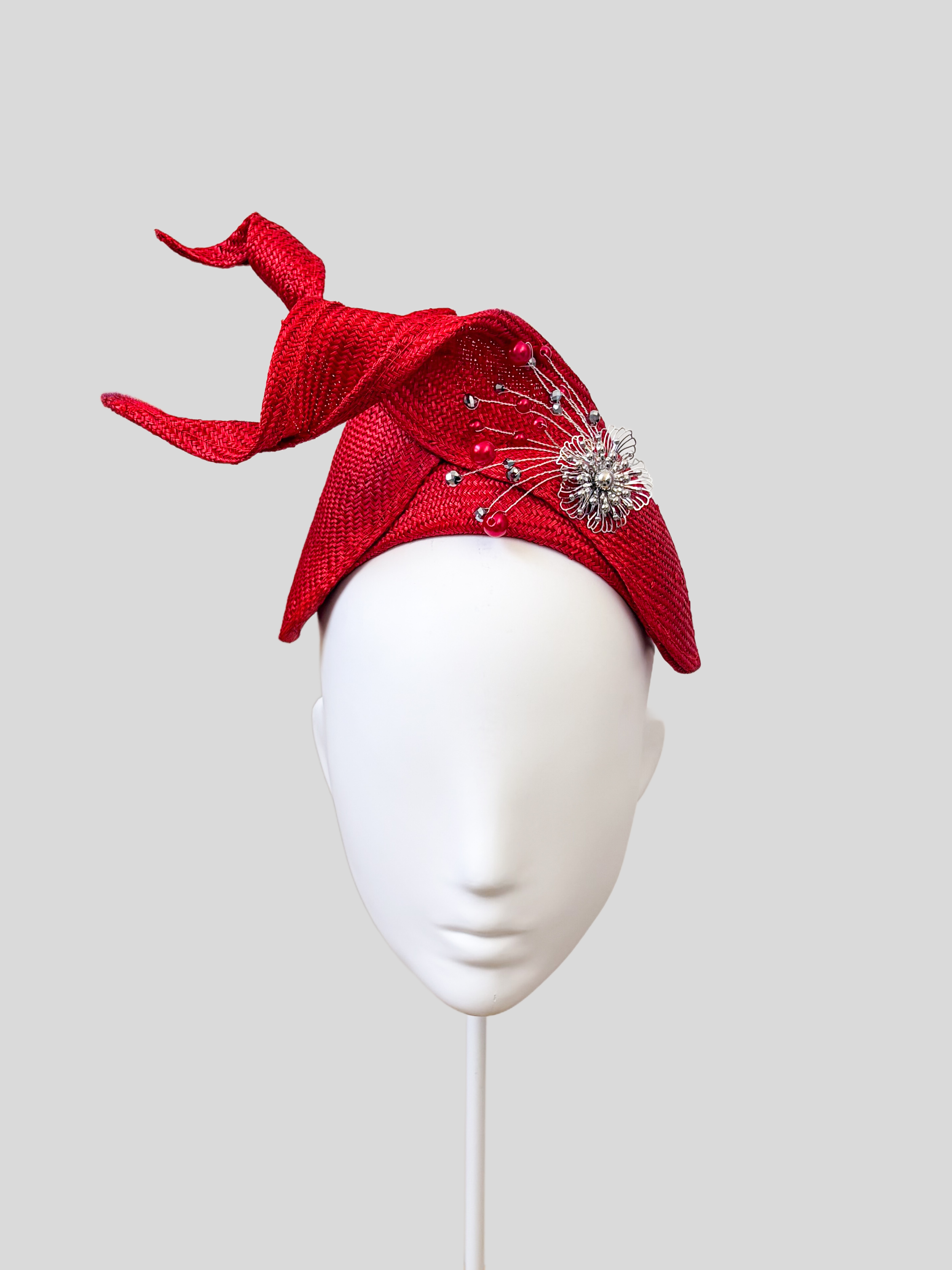 Front: SÉLÈNE Ruby Parisisal bandeau headband featuring sculptural twisted straw detailing and silver embellishment.