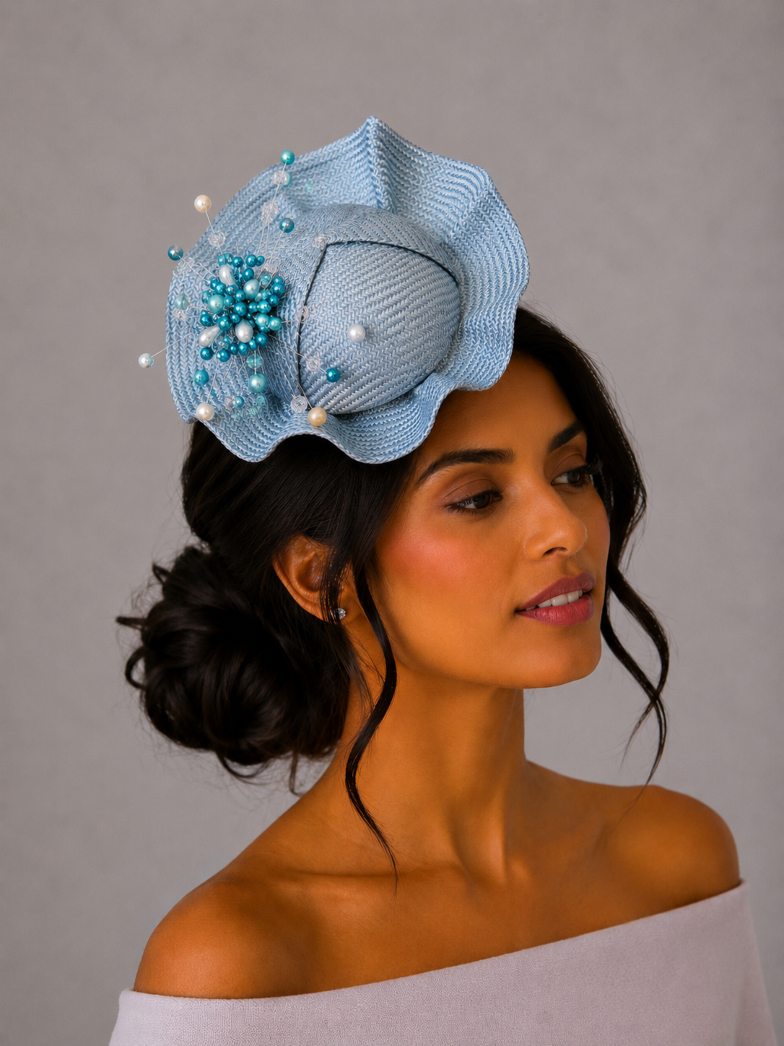 Model: VÉRA Sky Parisisal cocktail hat styled on a model, showcasing its sculptural silhouette and intricate hand-beaded embellishment.