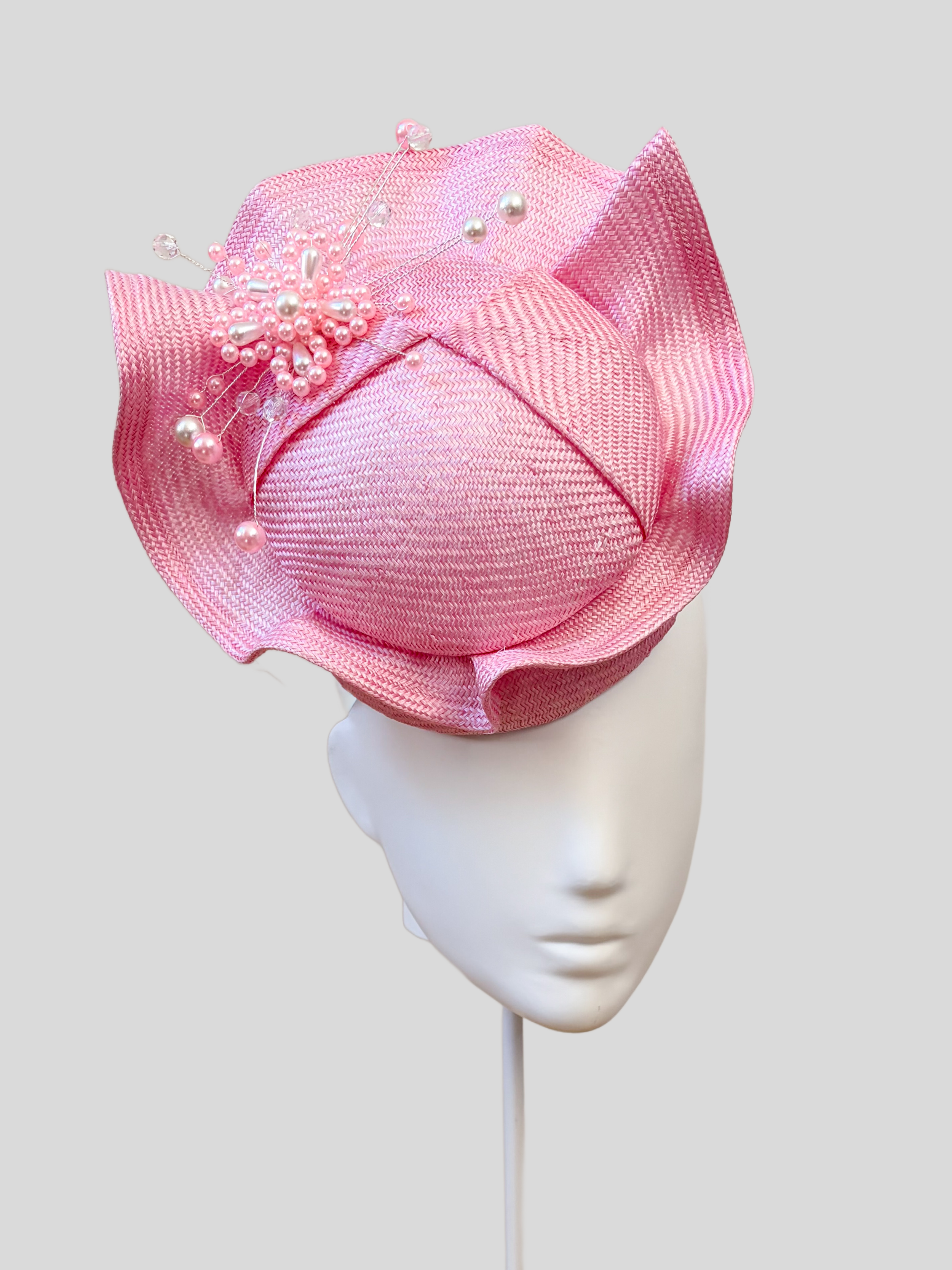 Left: Side view of the VÉRA Rose Parisisal cocktail hat showcasing its sculptural floating crown and rounded silhouette.