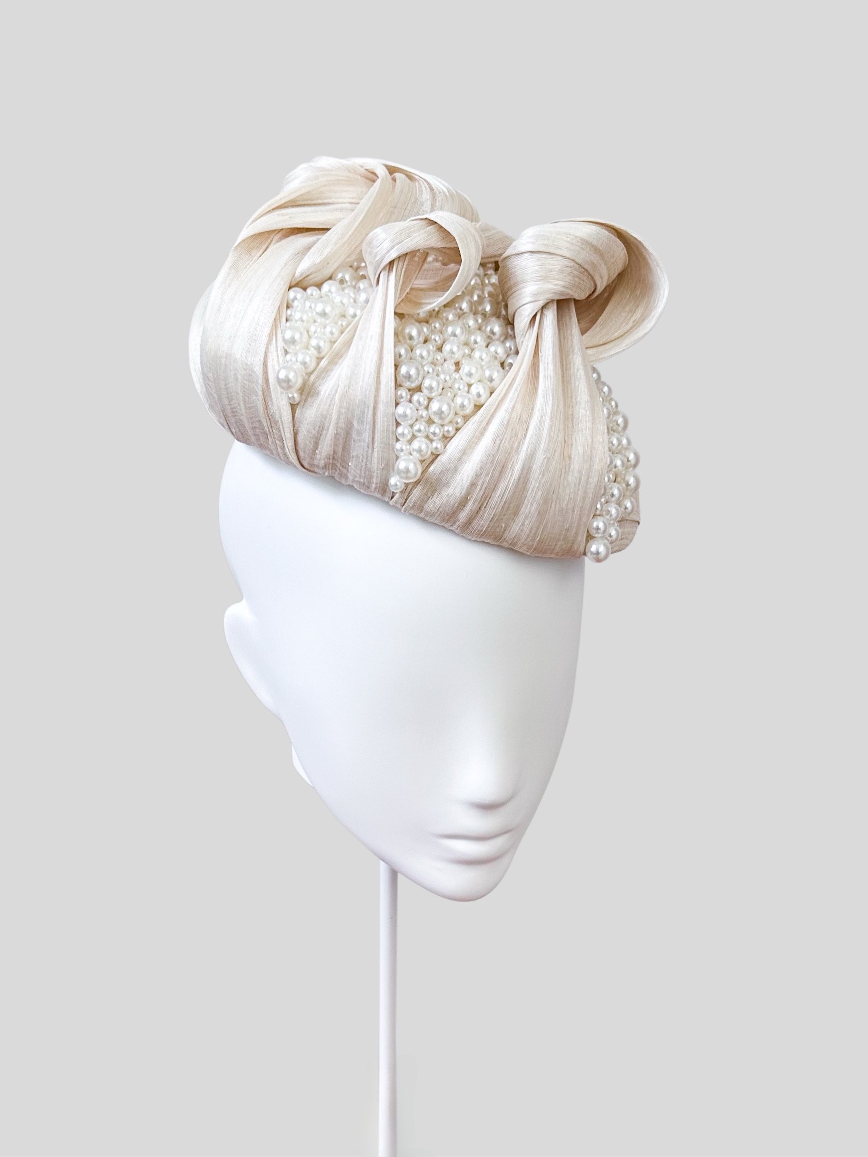 Left profile view of the "Avorio Perlata" face hugger. Observe the smooth flow of the ivory silk abaca and how the hand-beaded details subtly enhance the design.