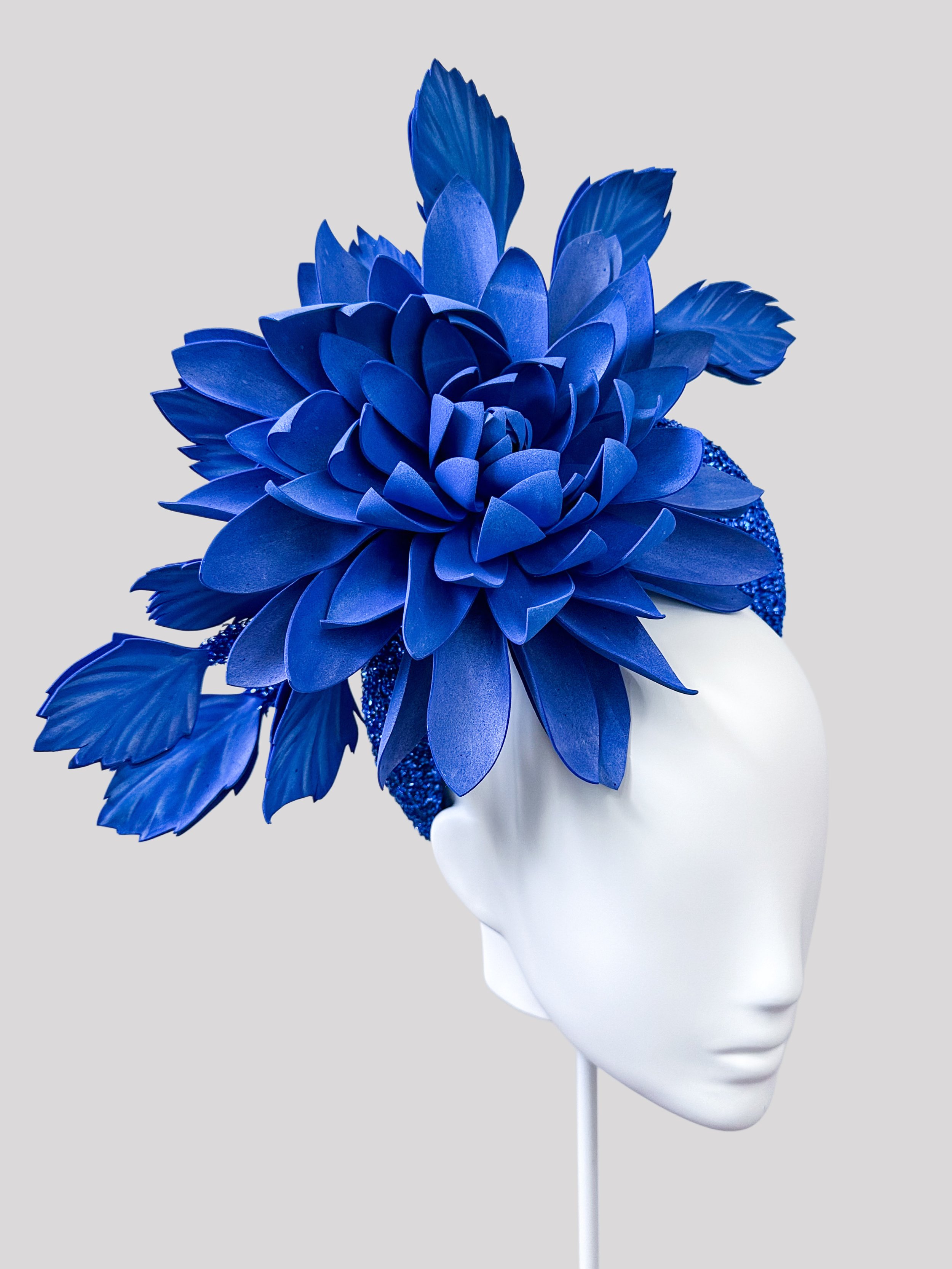 Left side view of the comfortable and on-trend OcéanoAzul blue metallic halo headband with its lightweight flower trim.