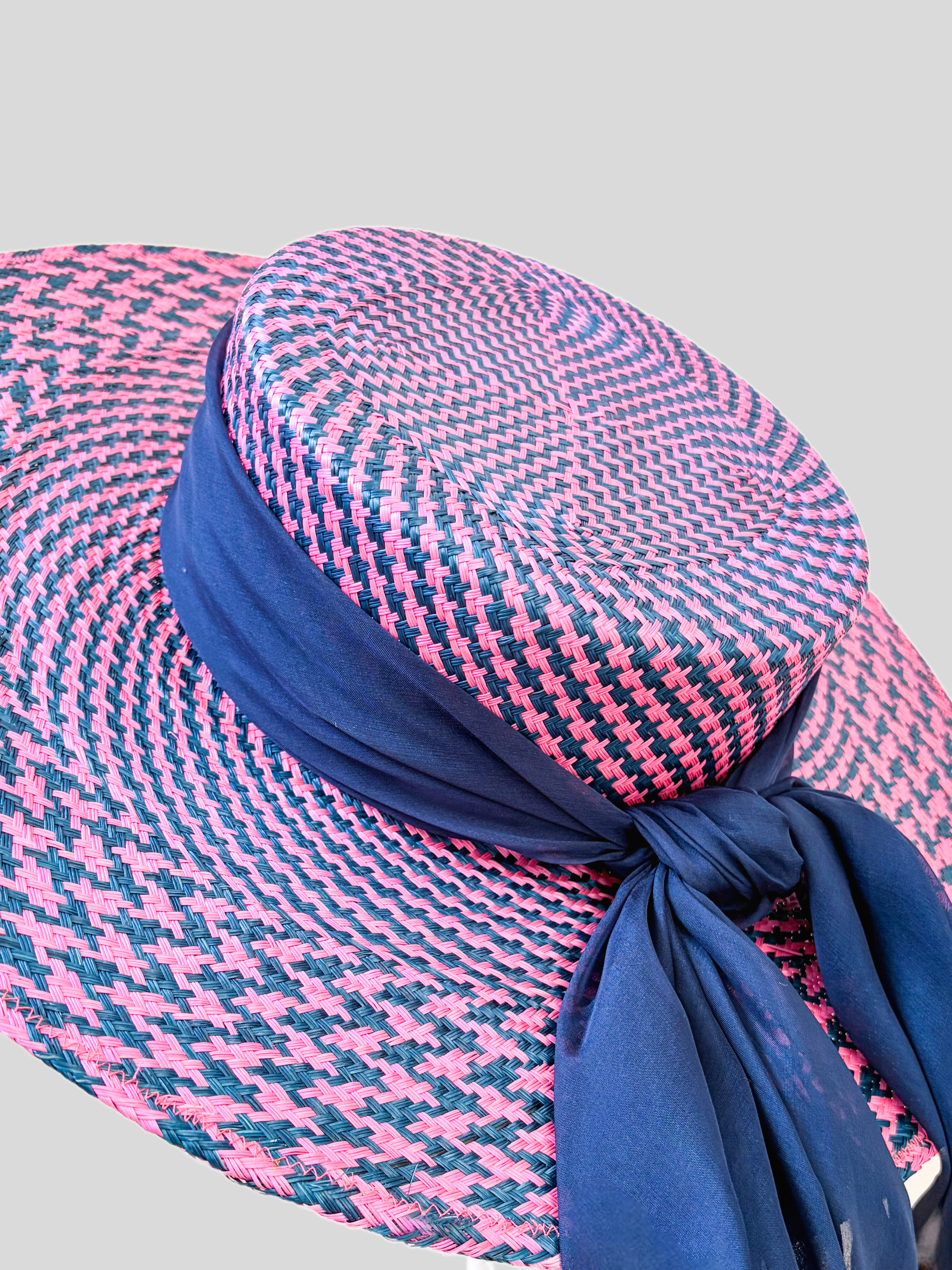 Close-up of Solara Cerise woven buntal texture and dark blue silk chiffon detailing.