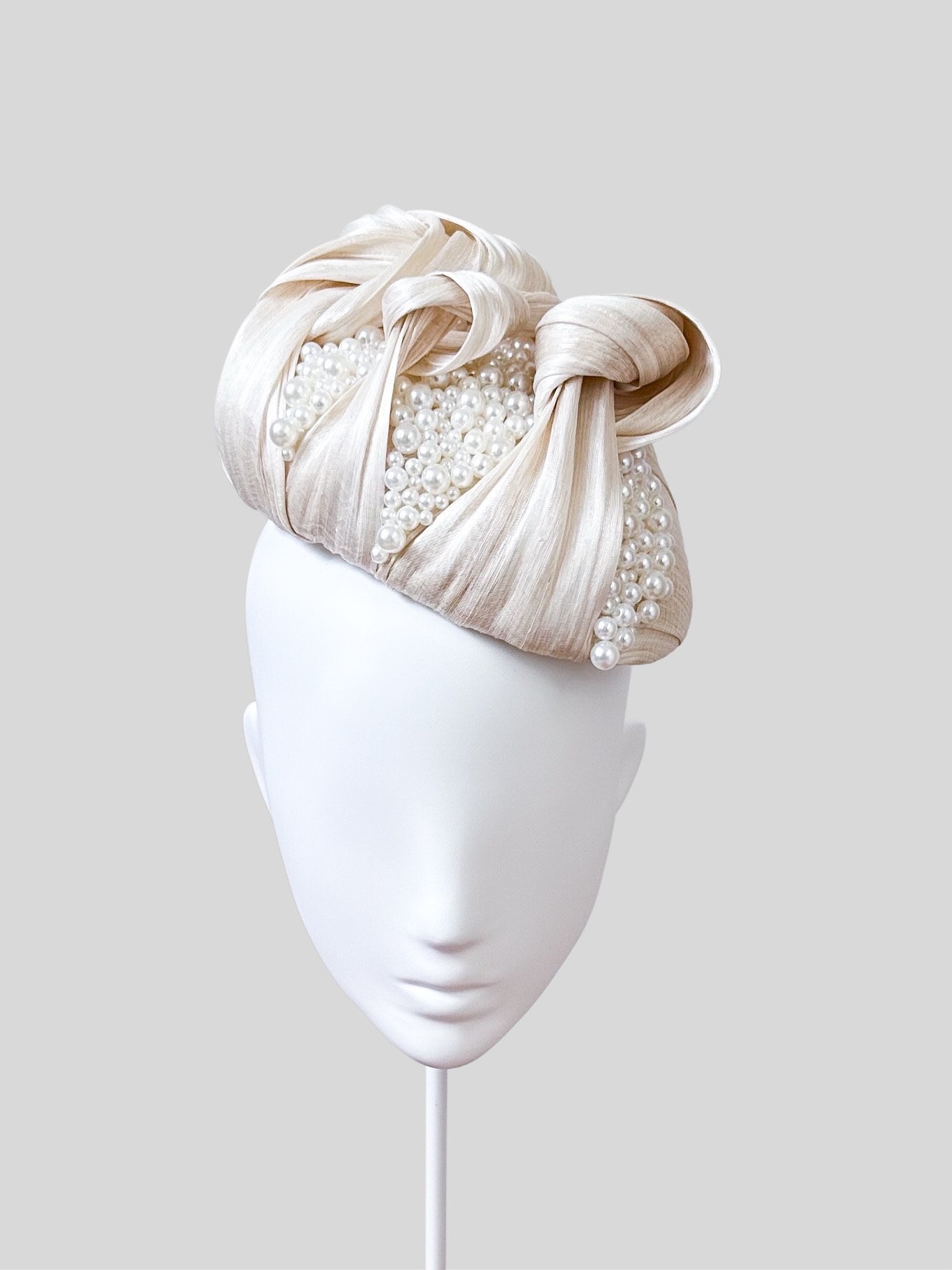 Front view of the "Avorio Perlata" ivory face hugger. Showcasing its modern silhouette and the elegant placement of the hand-beaded ivory details and knotted trim.