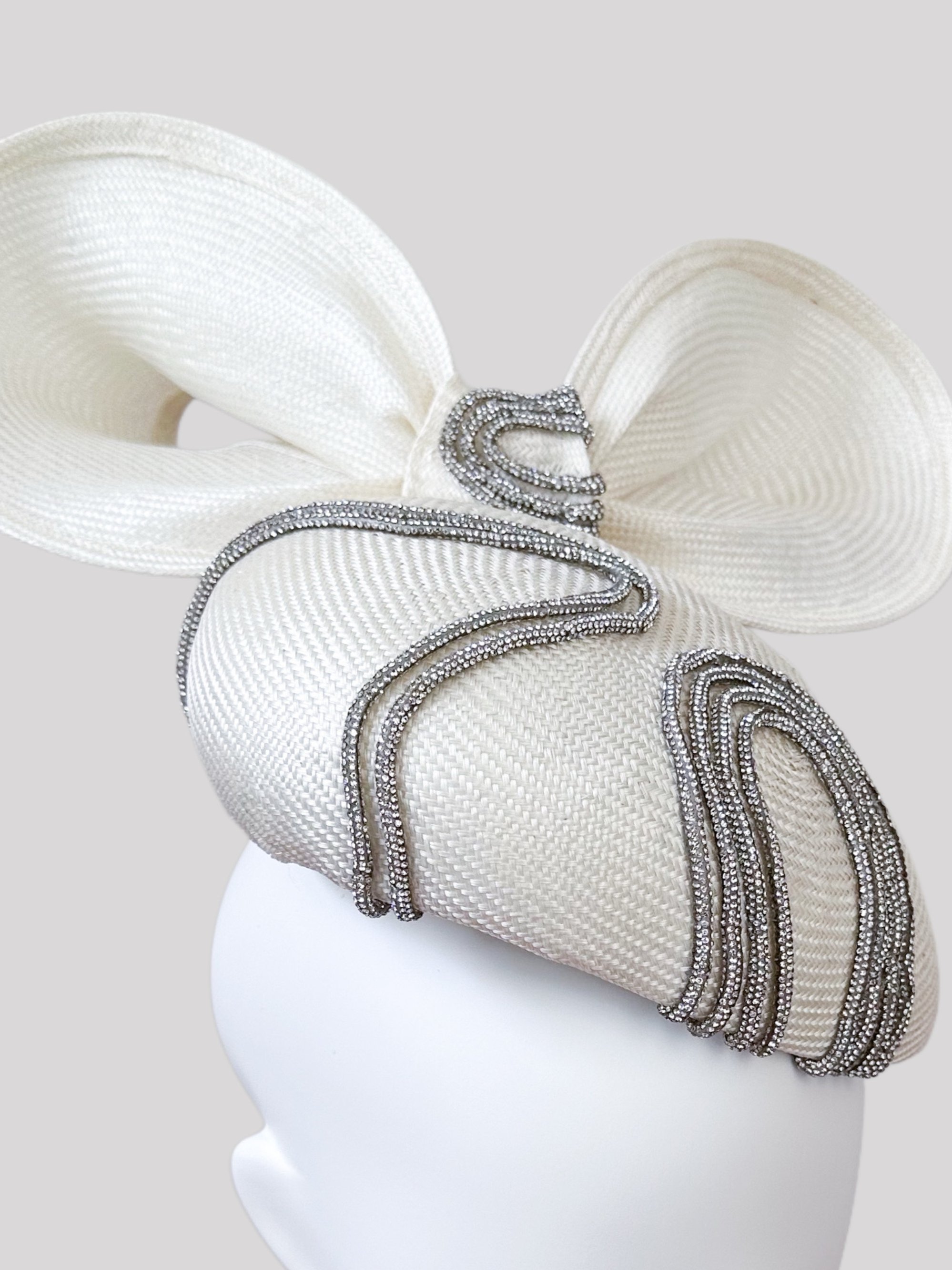 Detailed close-up of the "Sfavillio Avorio" face hugger. See the delicate texture of the off-white parisisal, the matching bow, and the subtle shimmer of the metallic silver rope trim.