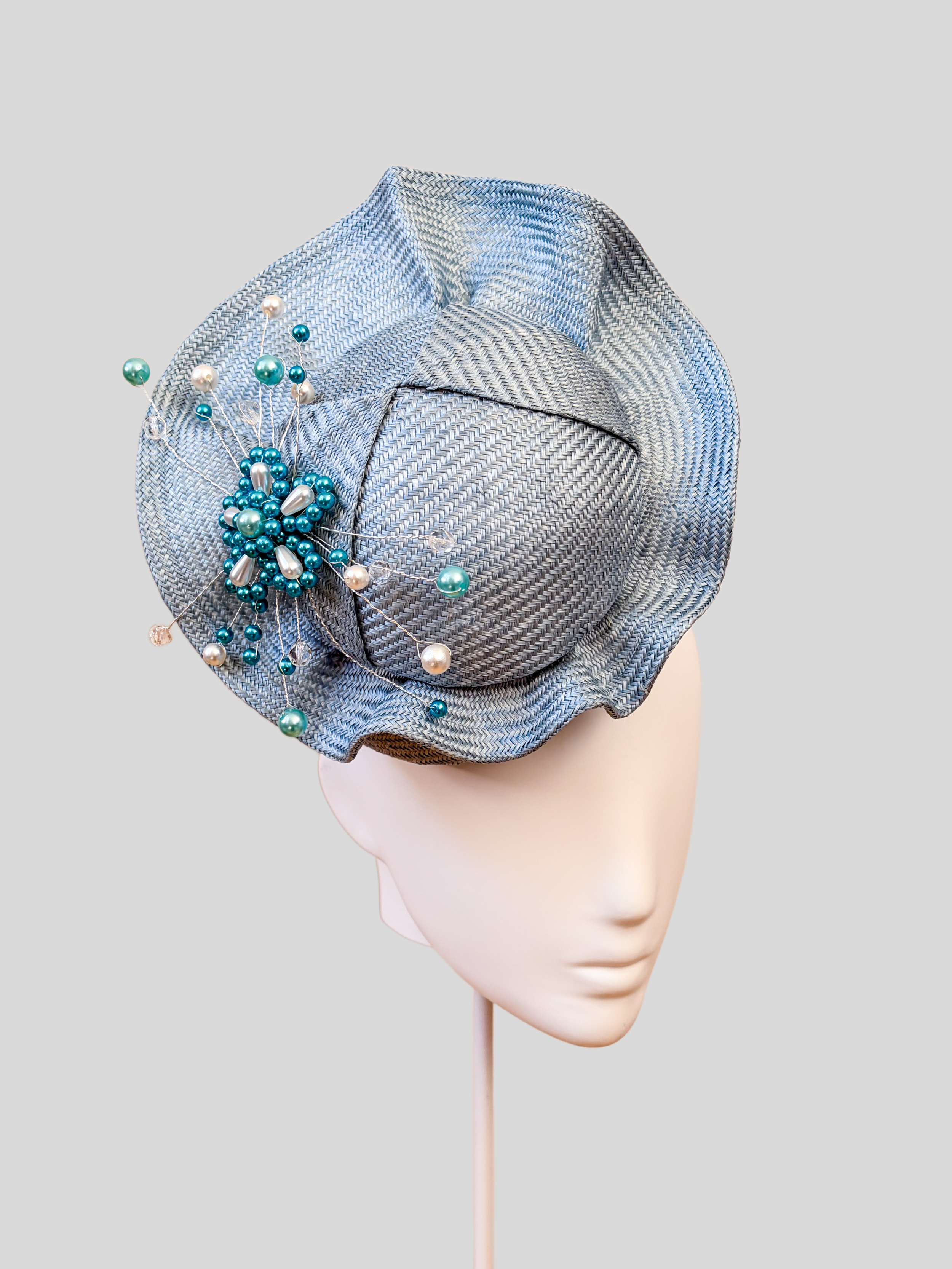 Left: Side view of the VÉRA Sky Parisisal cocktail hat showcasing its sculptural floating crown and rounded silhouette.