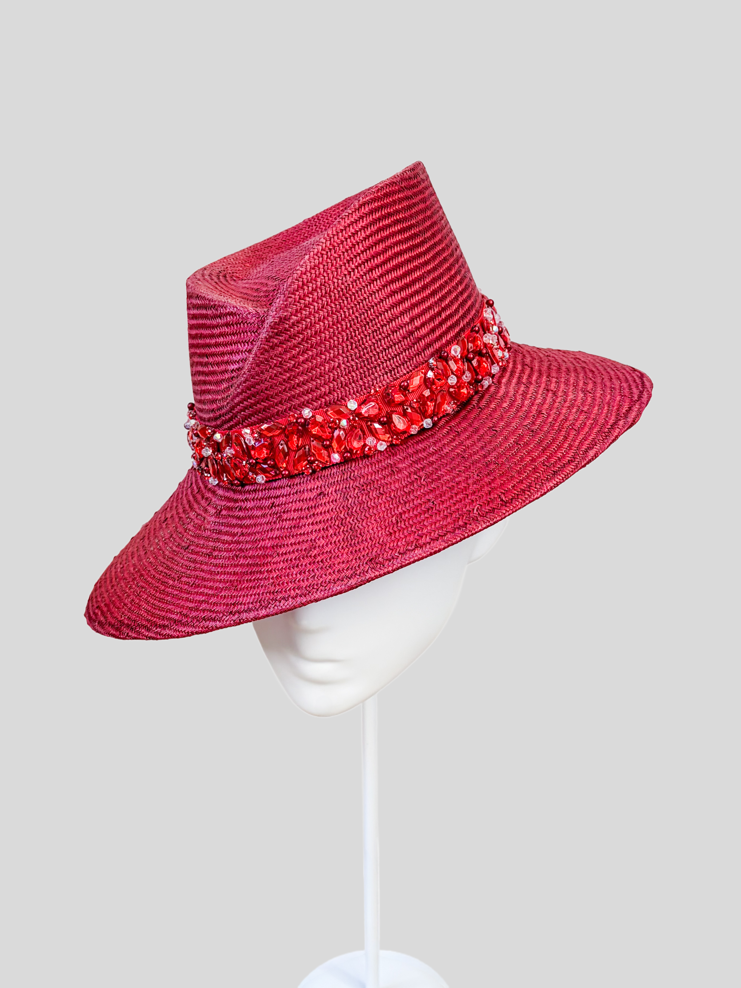 Right: Right-side view of the MAISON Ruby Parisisal fedora highlighting its rich ruby-red finish and tonal embellishment.