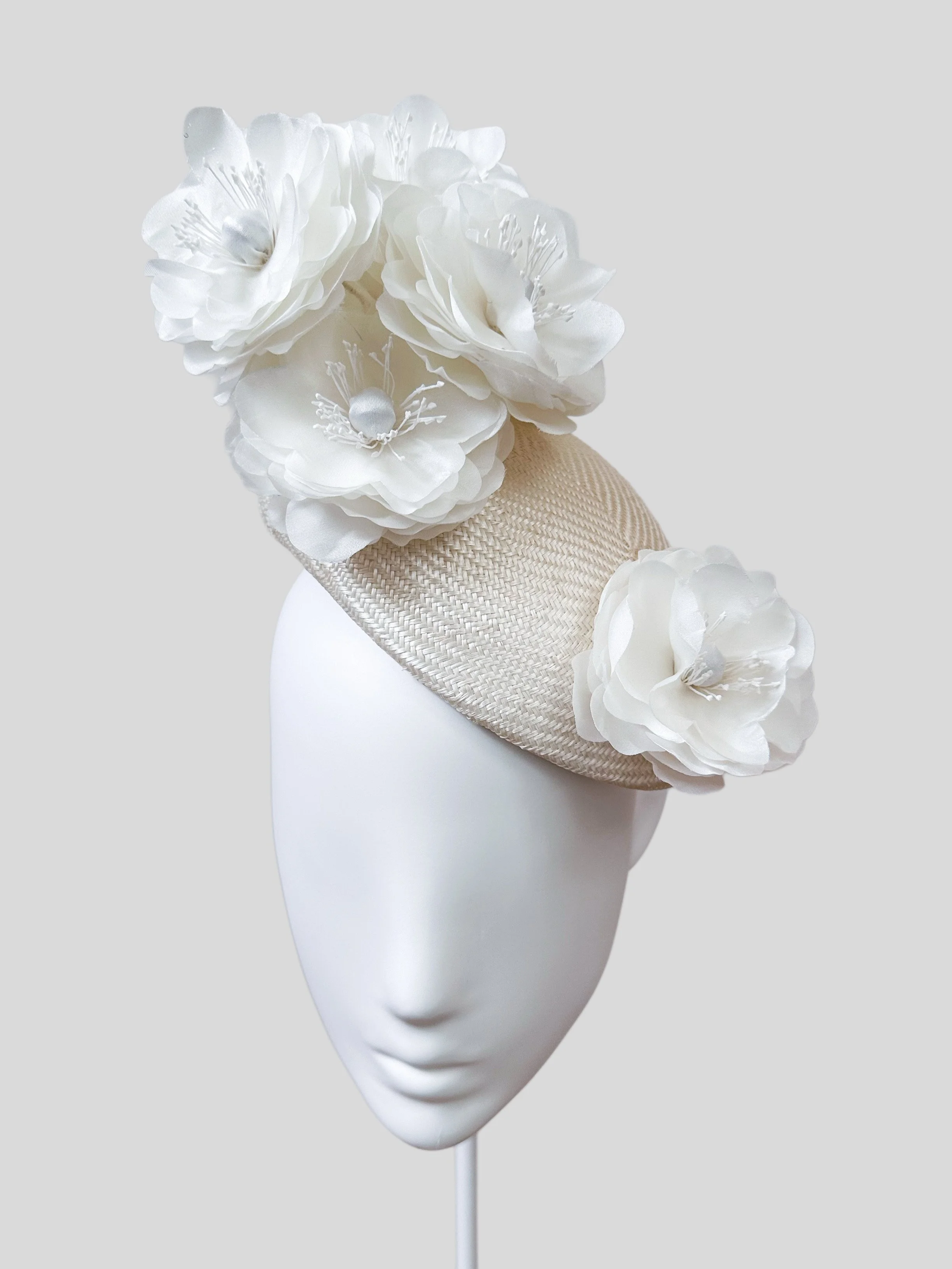 Front view of the elegant Ivory Face Hugger hat. A timeless and classic accessory with delicate handmade silk flowers, perfect for any special occasion.