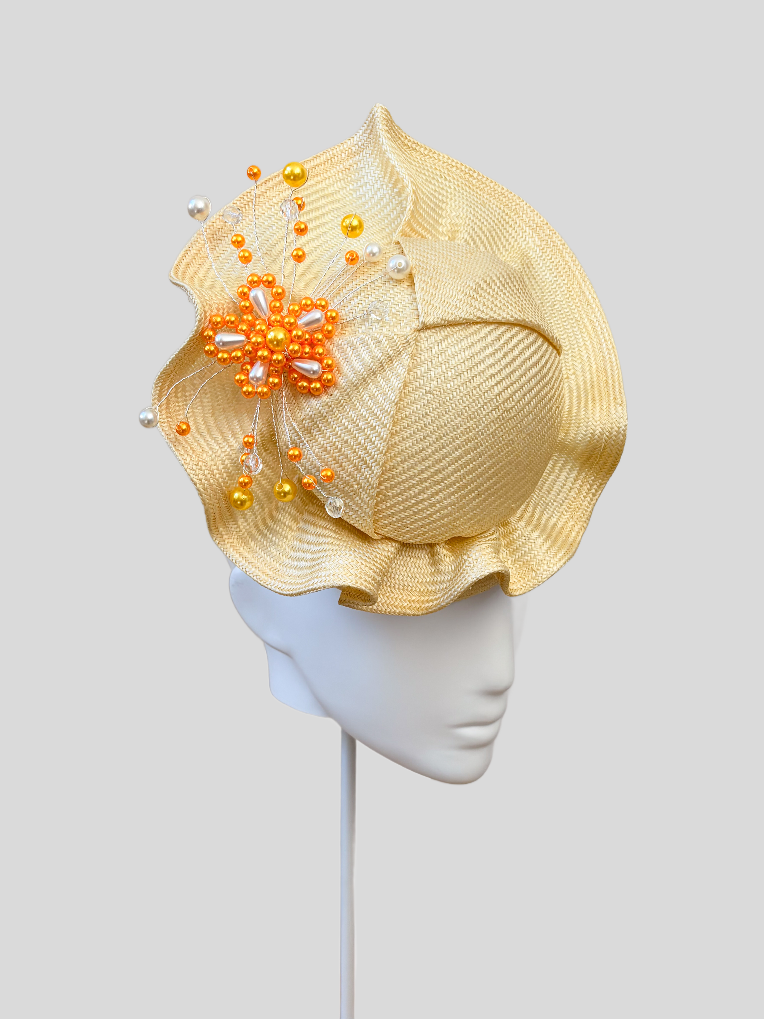 Left: Side view of the VÉRA Citrine Parisisal cocktail hat showcasing its sculptural floating crown and rounded silhouette.
