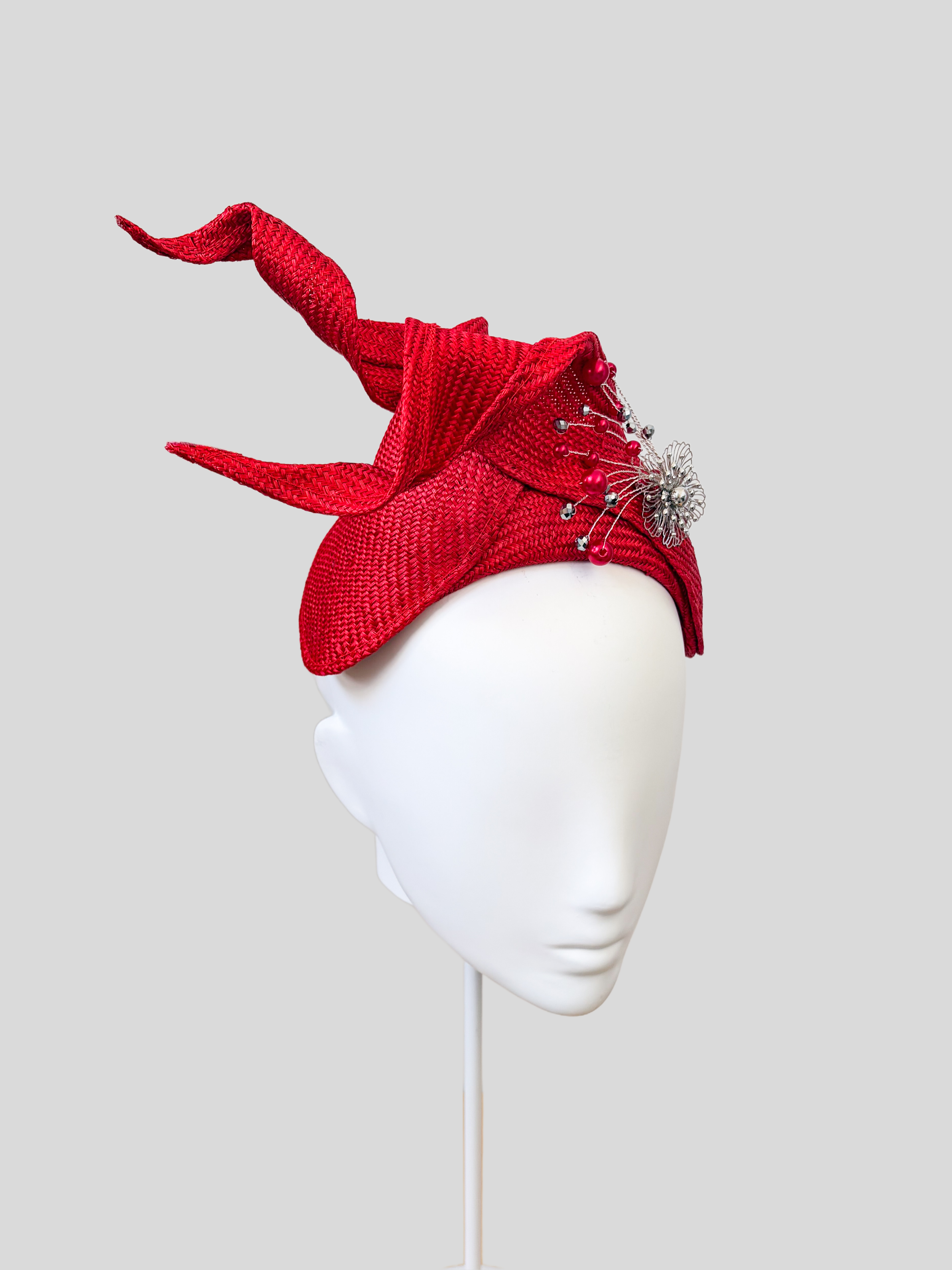 Left: Side view of the SÉLÈNE Ruby Parisisal bandeau headband showcasing its twisted sculptural Parisisal detail.