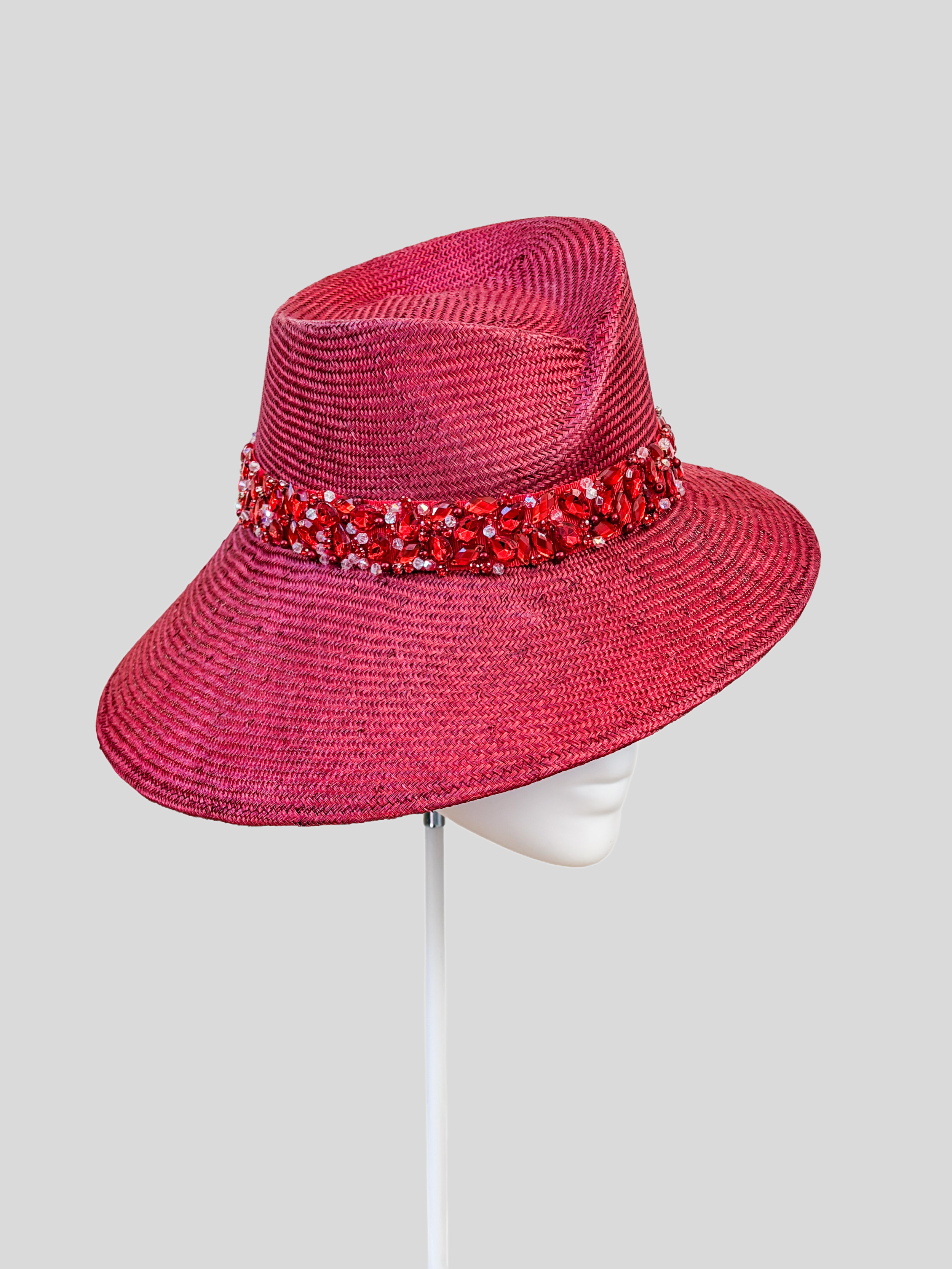 Left: Side view of the MAISON Ruby Parisisal fedora showcasing its sculptural crown and hand-embellished band.