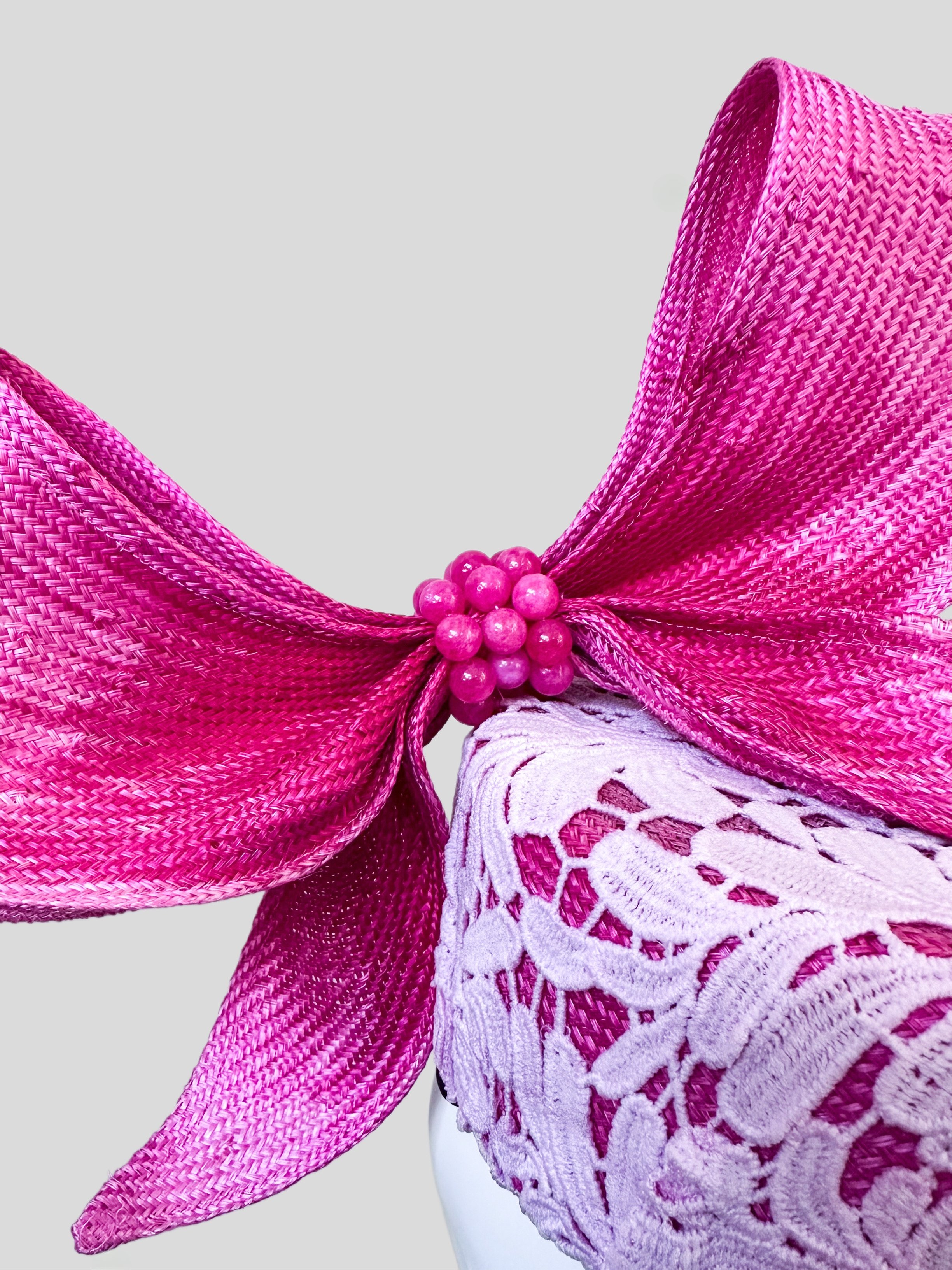 Close-up of the Ombre Lace Pillbox with Parisial Bow, highlighting the intricate pink lace texture and the unique ombre pink wired bow design.