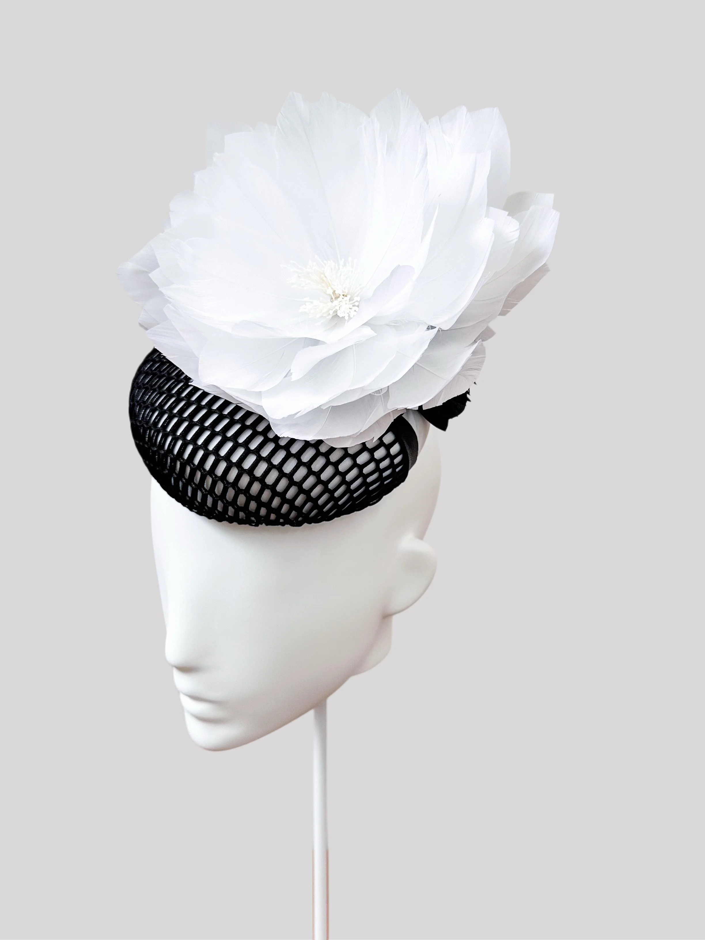A right-side view of the Fiore Bianco cocktail hat, revealing the intricate lace and leather base and the stunning handcrafted flowers from a different angle.