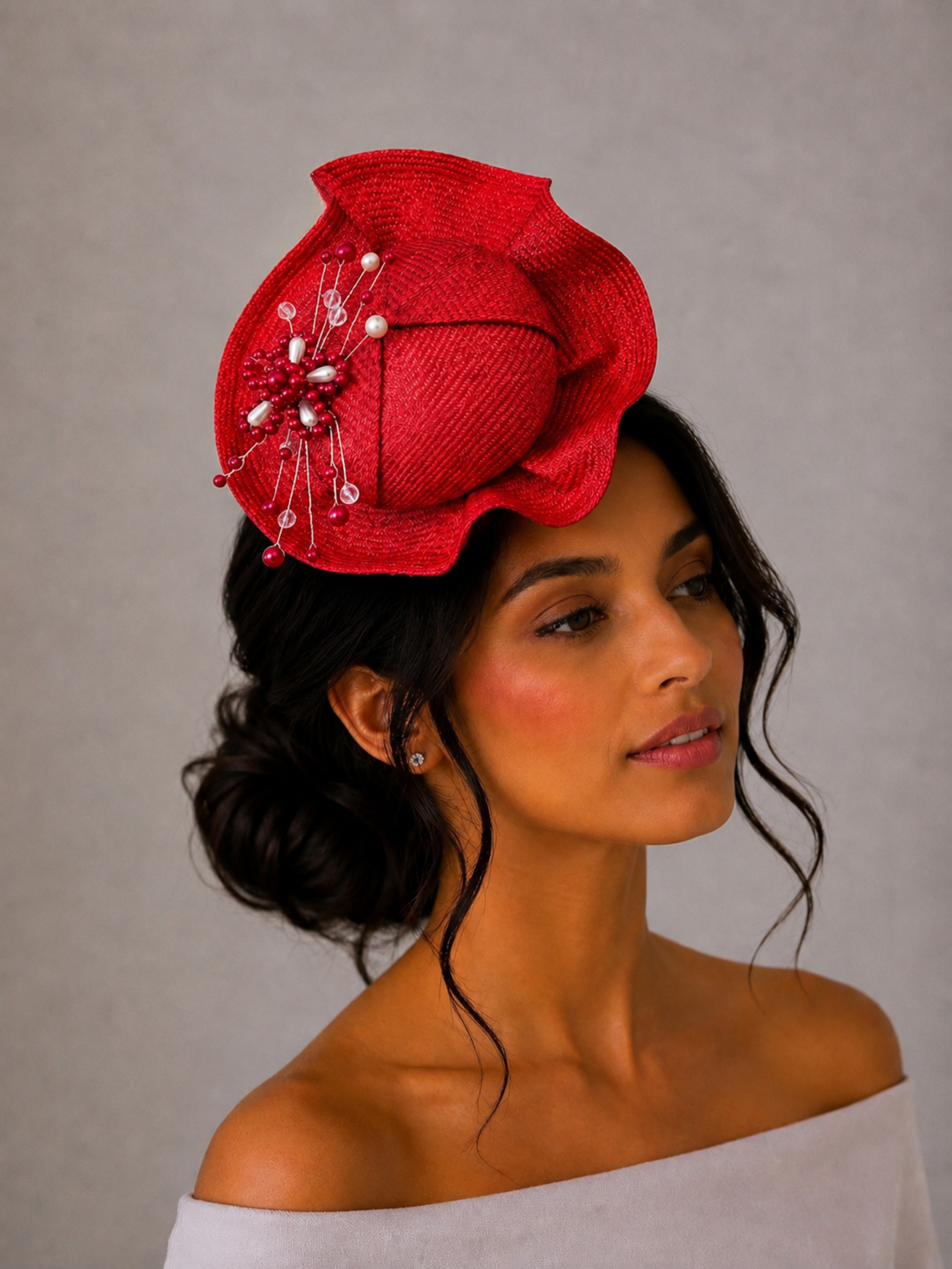 Model: VÉRA Ruby Parisisal cocktail hat styled on a model, showcasing its sculptural silhouette and intricate hand-beaded embellishment.
