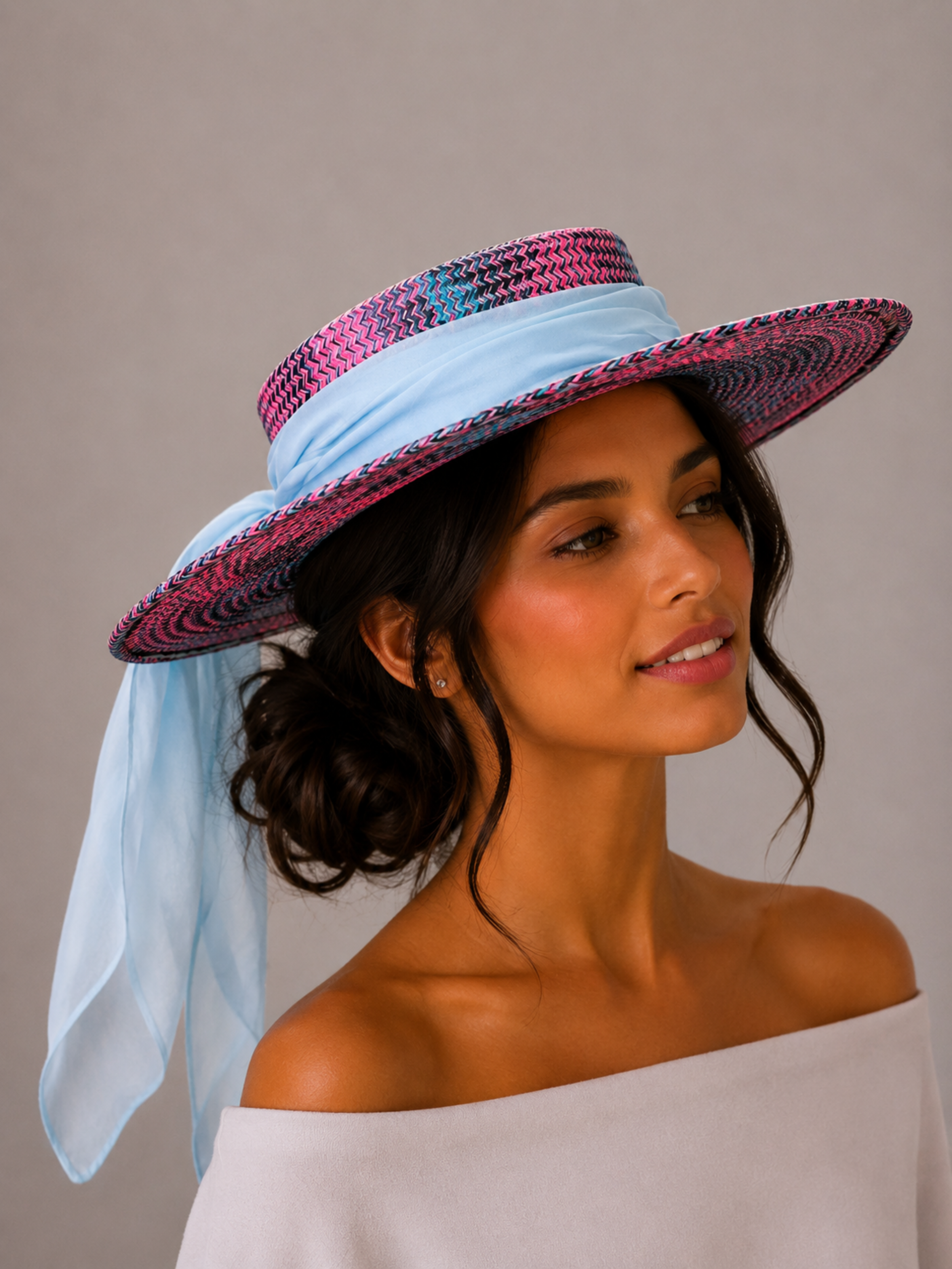 Solara Capri woven boater hat styled on a model with a flowing sky blue silk chiffon tie.