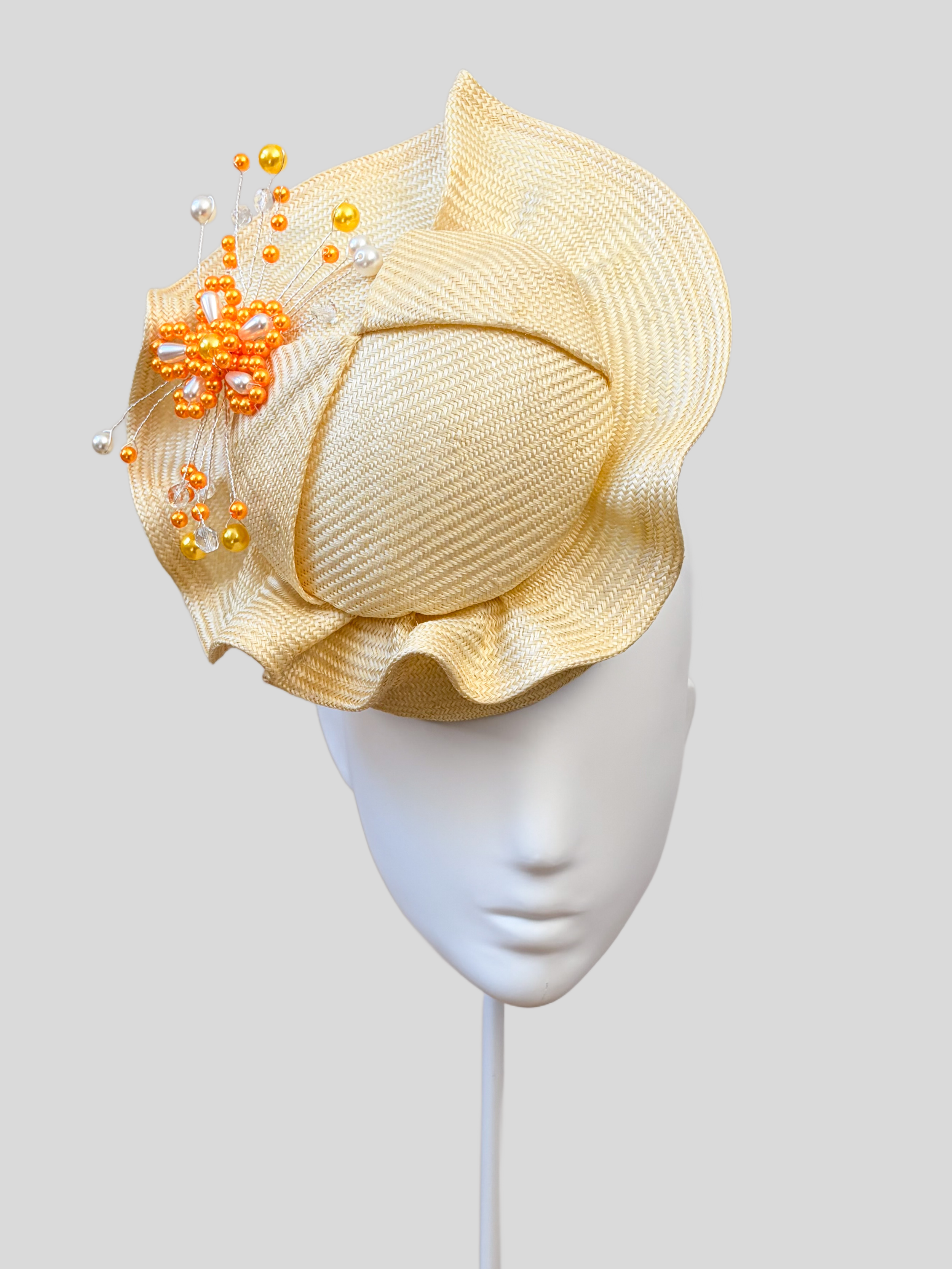Front: VÉRA Citrine Parisisal cocktail hat featuring a sculptural floating crown and hand-beaded yellow embellishment.