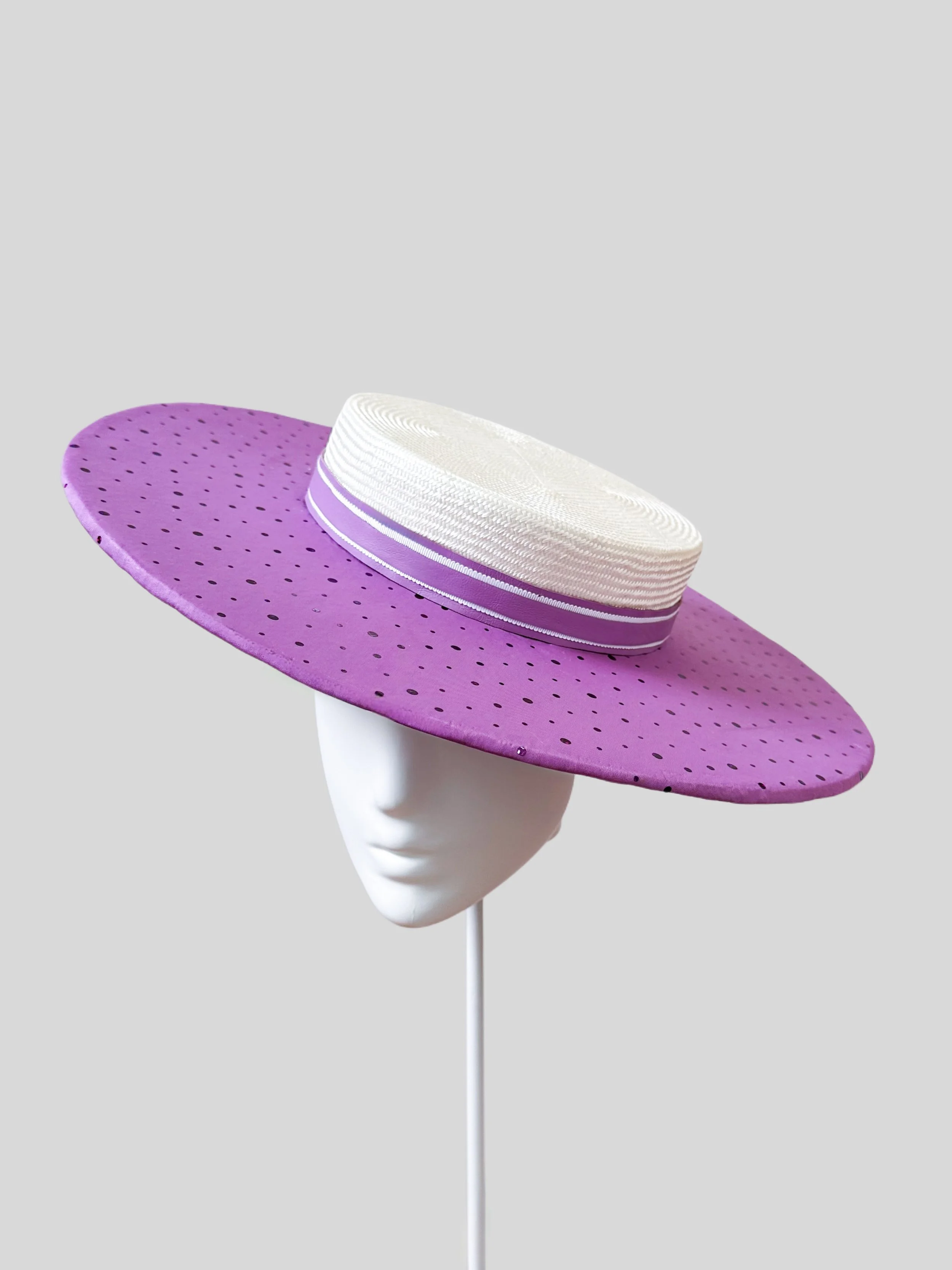 A beautiful right-side view of the ivory and purple boater hat, highlighting its classic shape and unique handmade design.