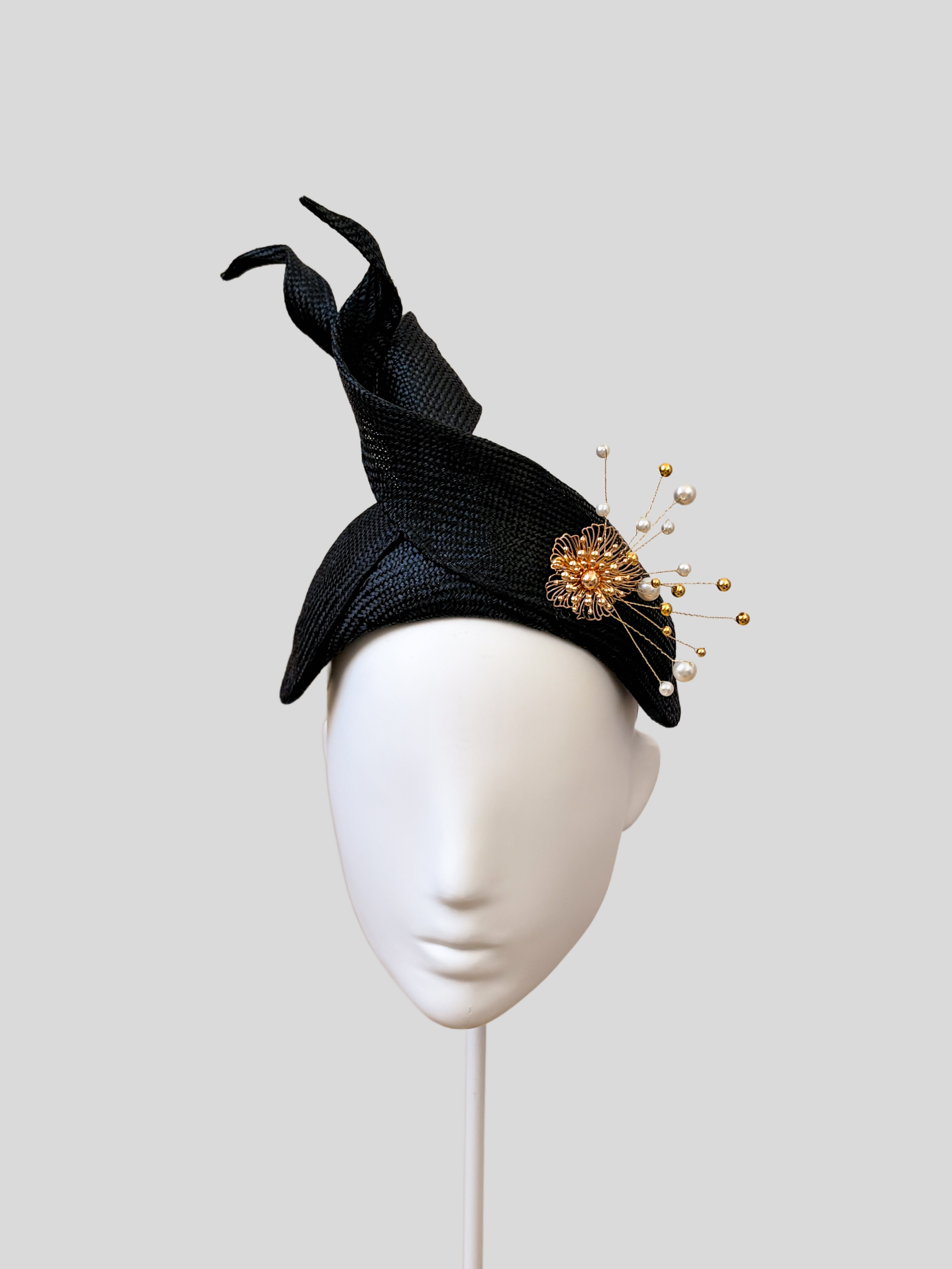 Front: SÉLÈNE Noir Parisisal bandeau headband featuring sculptural twisted straw detailing and gold embellishment.